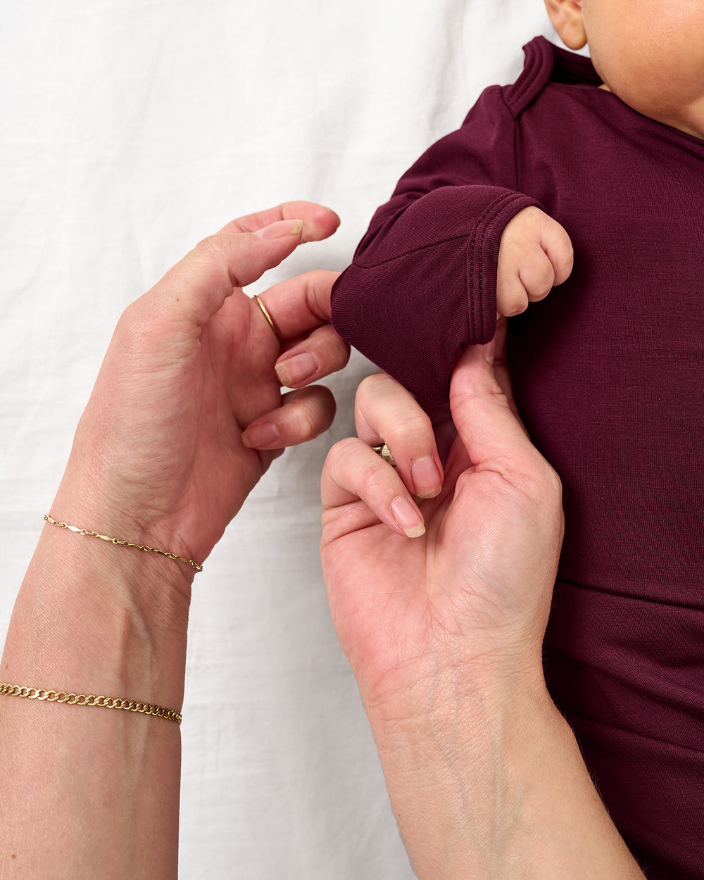 Adult demonstrating the hand foldover feature on the Classic Burgundy Infant Gown