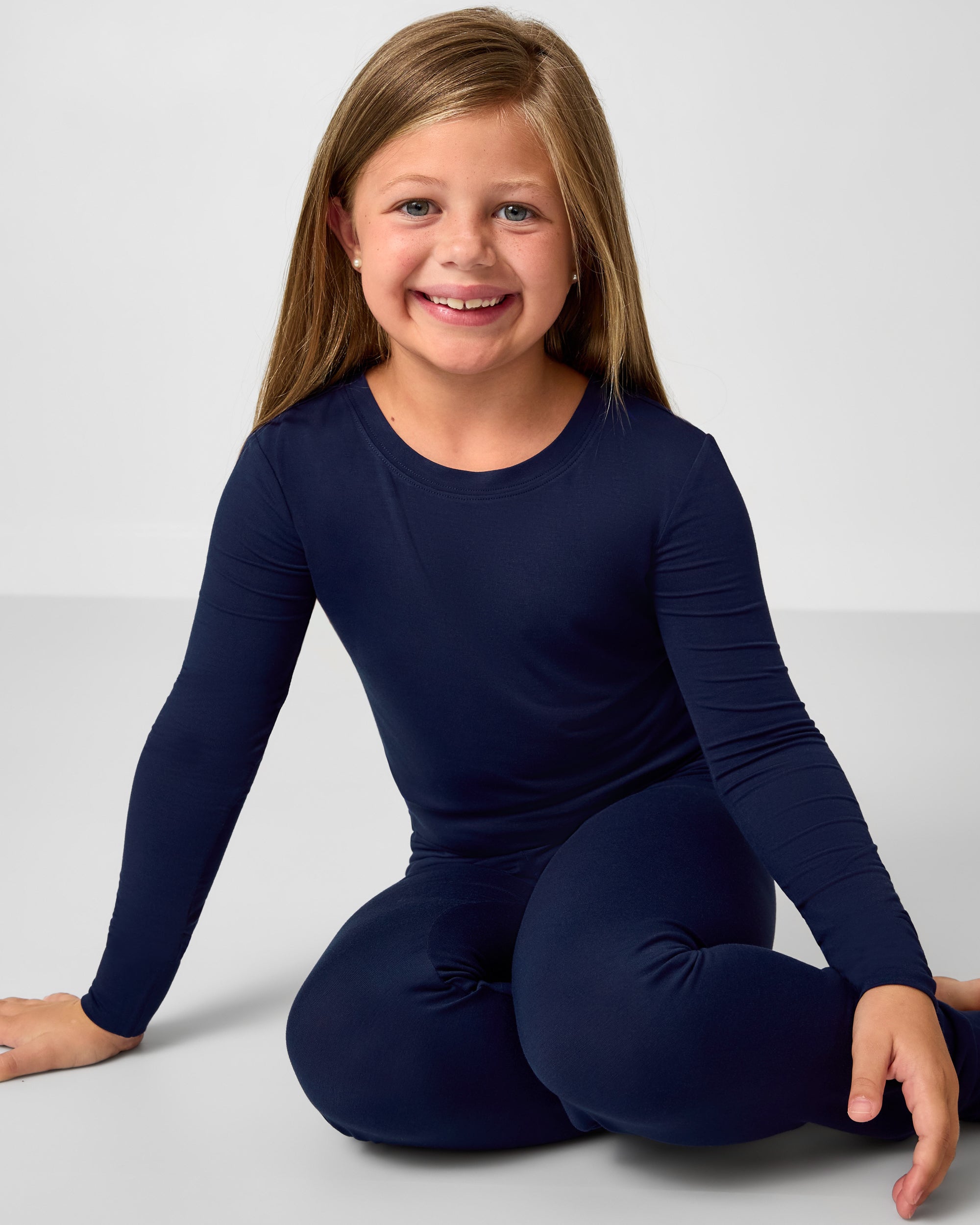 Sitting girl wearing the Classic Navy Two-Piece Pajama Set
