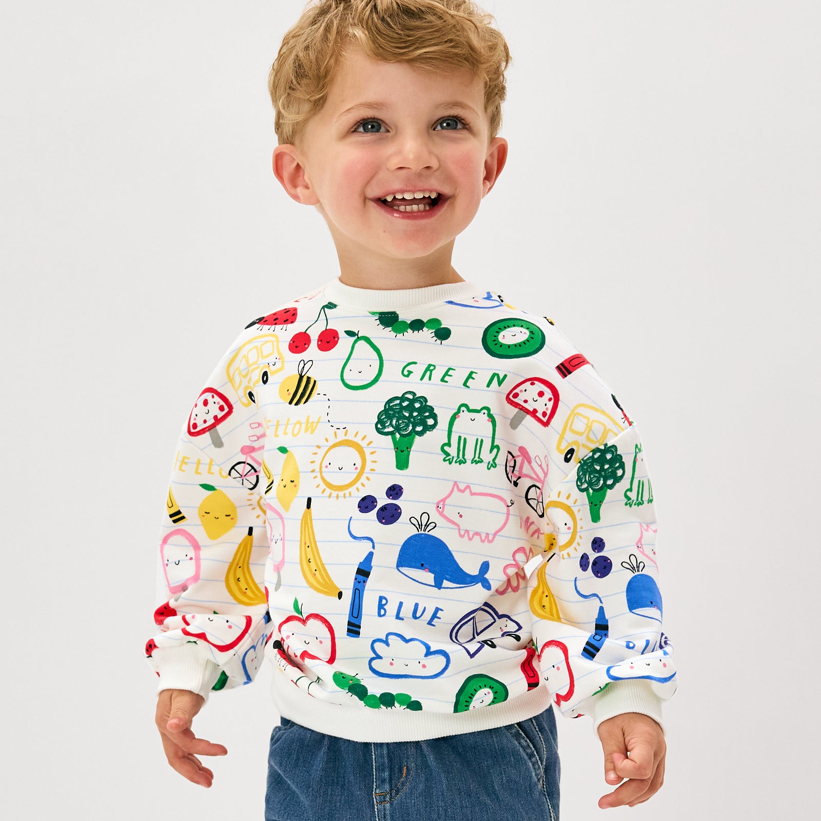 Smiling child wearing the Coloring Crew Drop Shoulder Crewneck