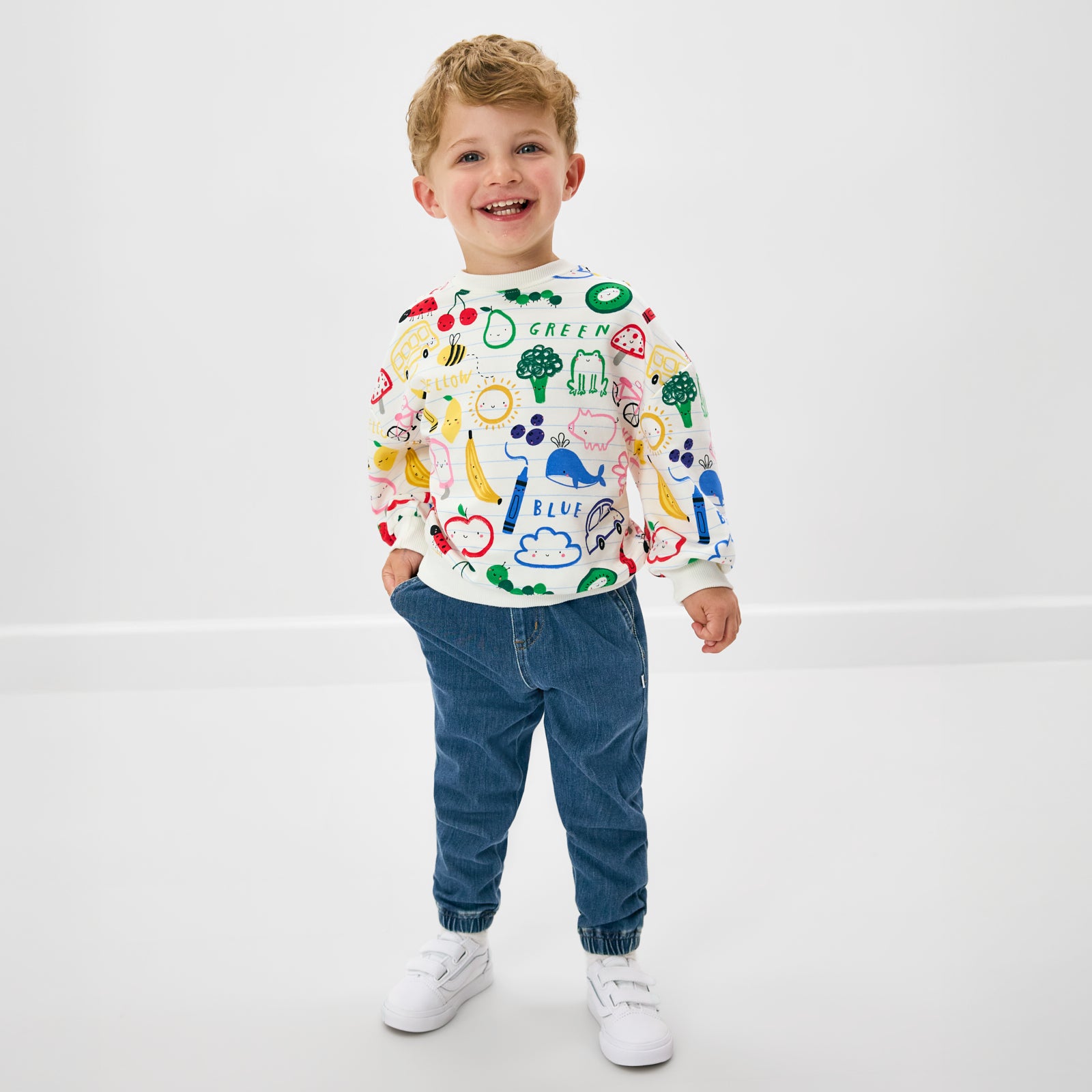 Standing child wearing the Coloring Crew Drop Shoulder Crewneck with blue denim joggers