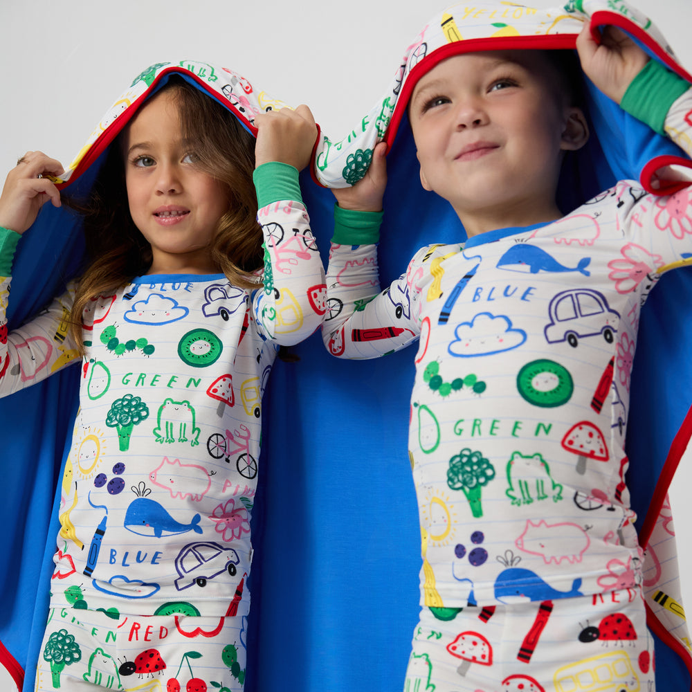 Two children wrapped in the Coloring Crew Large Cloud Blanket®