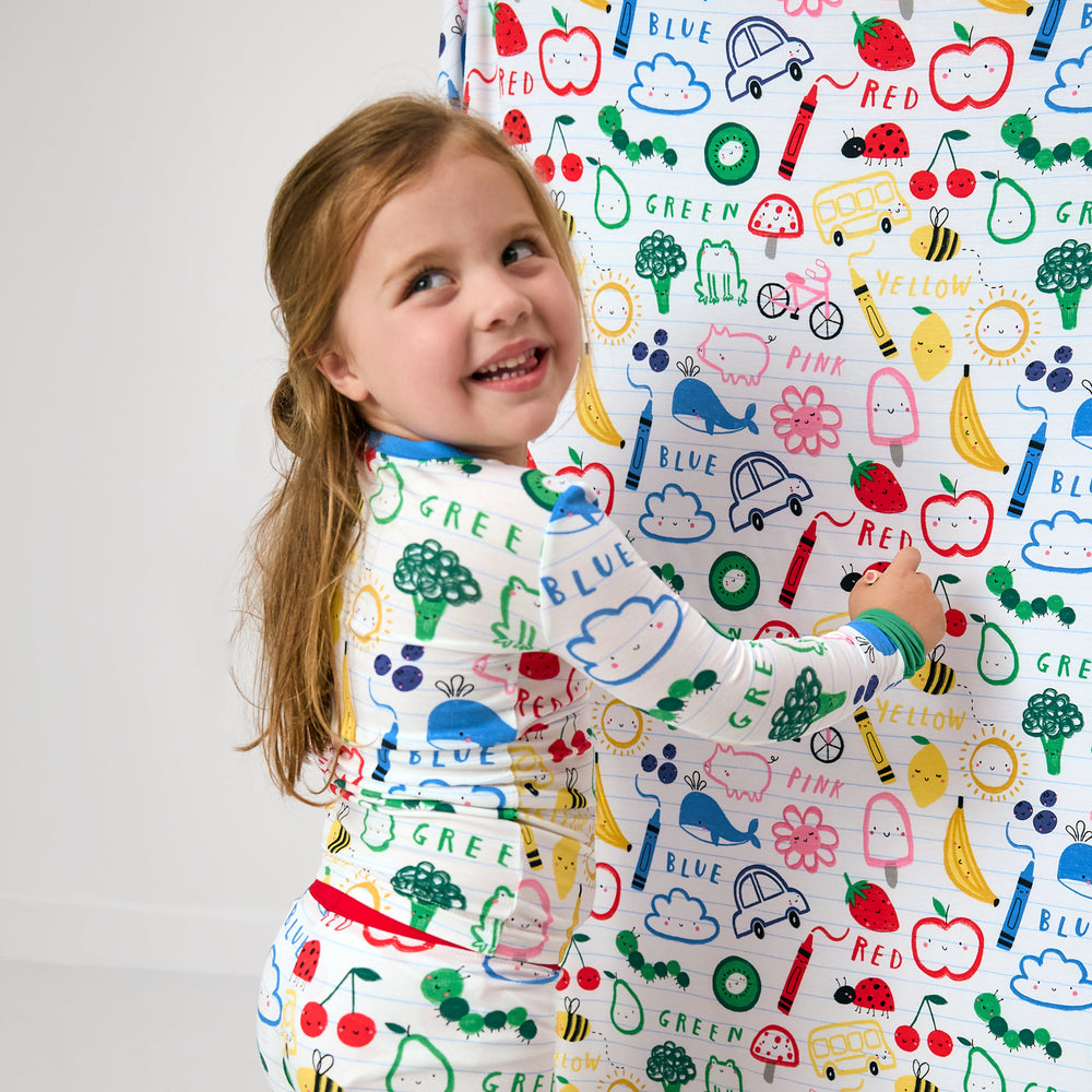 Child pretending to write on the Coloring Crew Large Cloud Blanket®