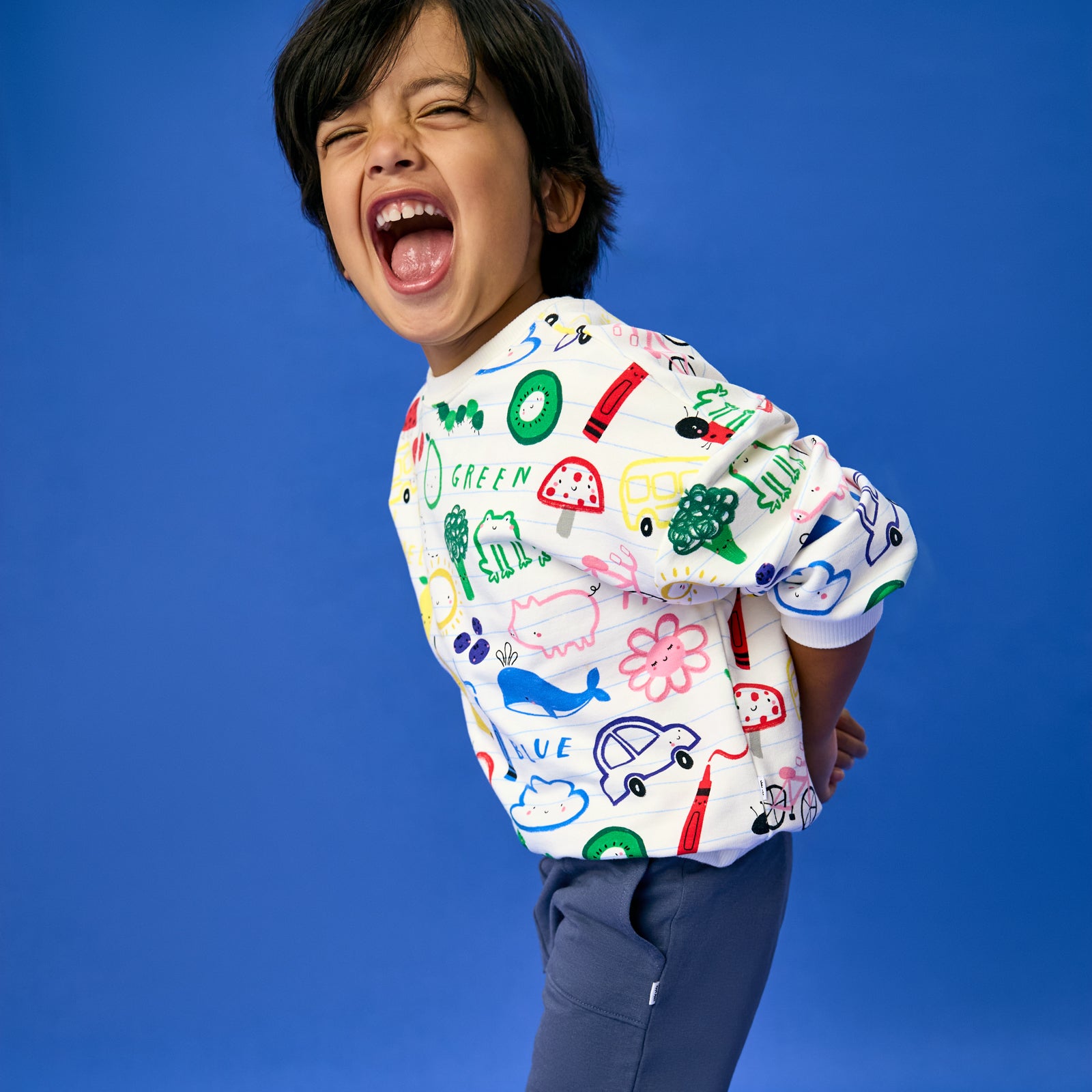Excited child wearing the Coloring Crew Drop Shoulder Crewneck