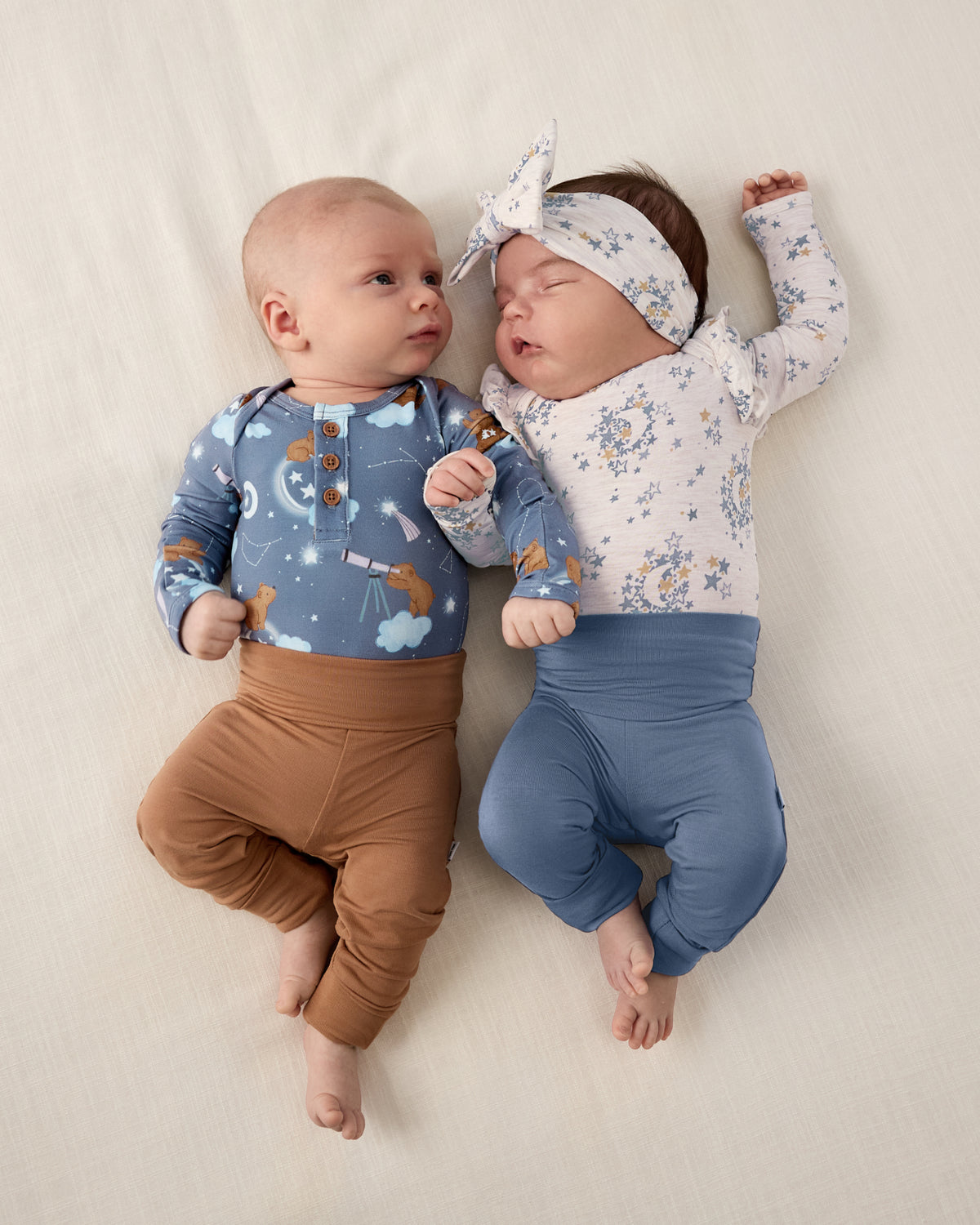 Two newborns wearing styles from the Newborn Capsule