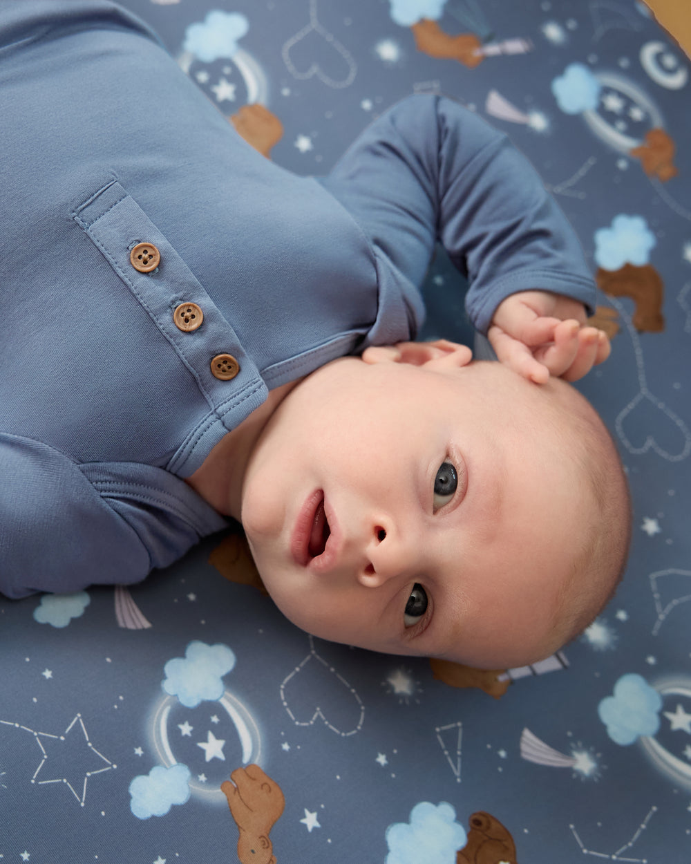 Close up of newborn boy wearing the Hazy Blue Henley Bodysuit
