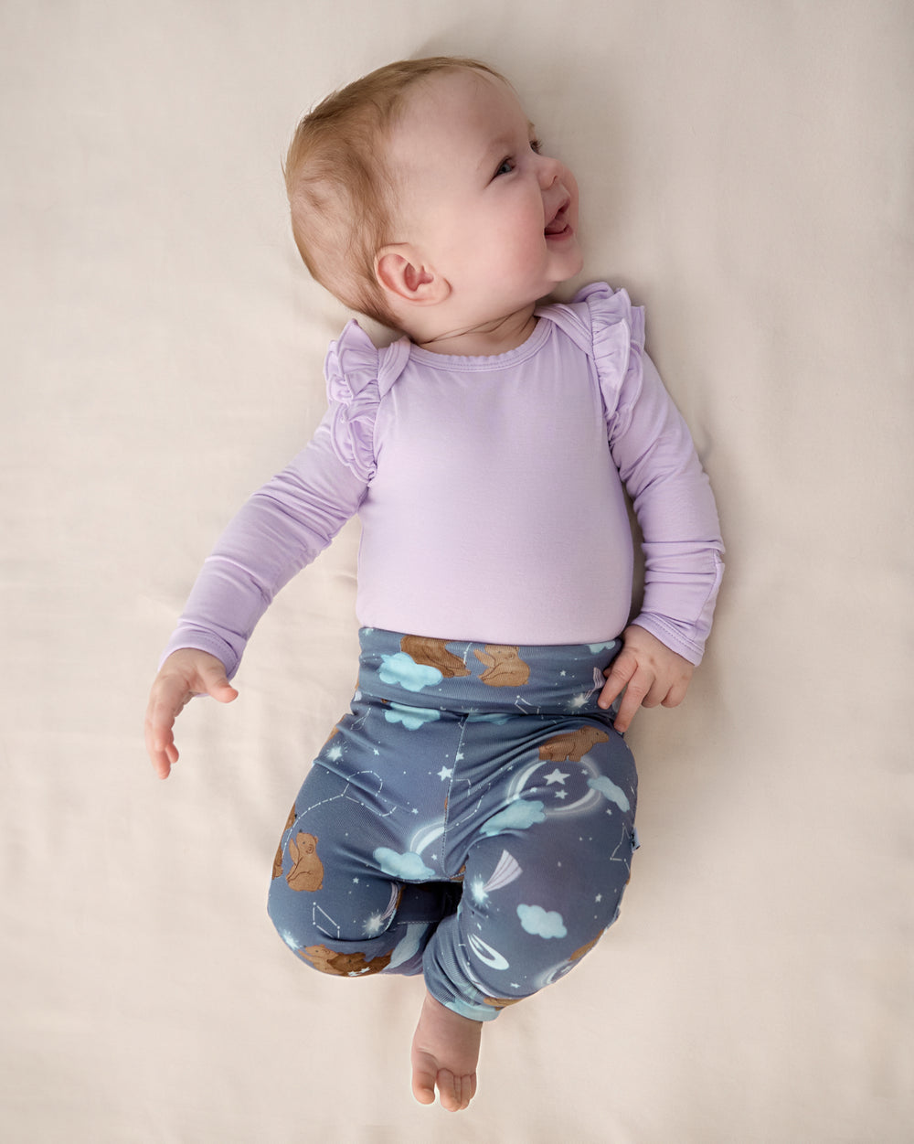 Newborn wearing the Constellation Cubs Fold Over Legging with a purple bodysuit