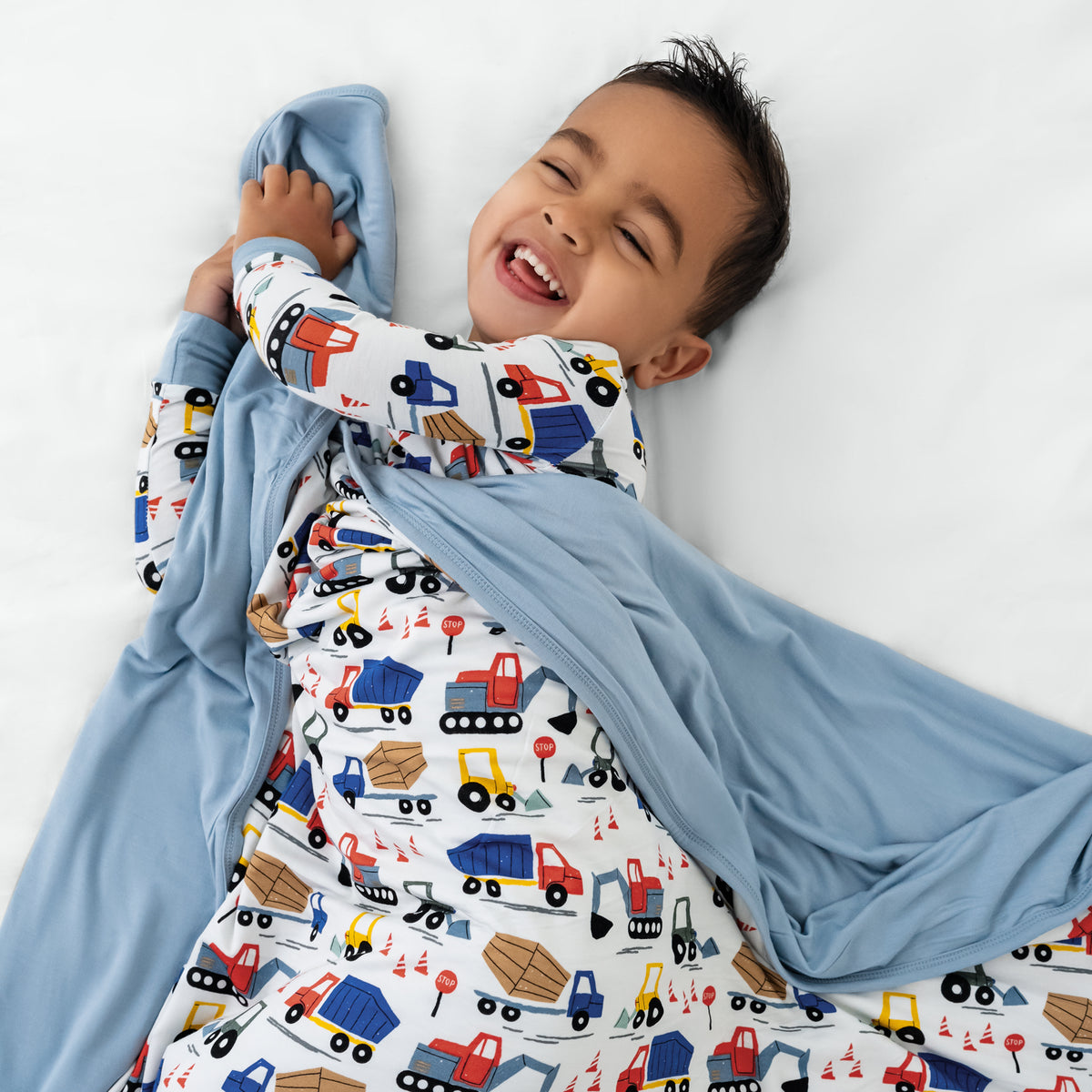 Aerial view of child wrapped in the Construction Large Cloud Blanket®