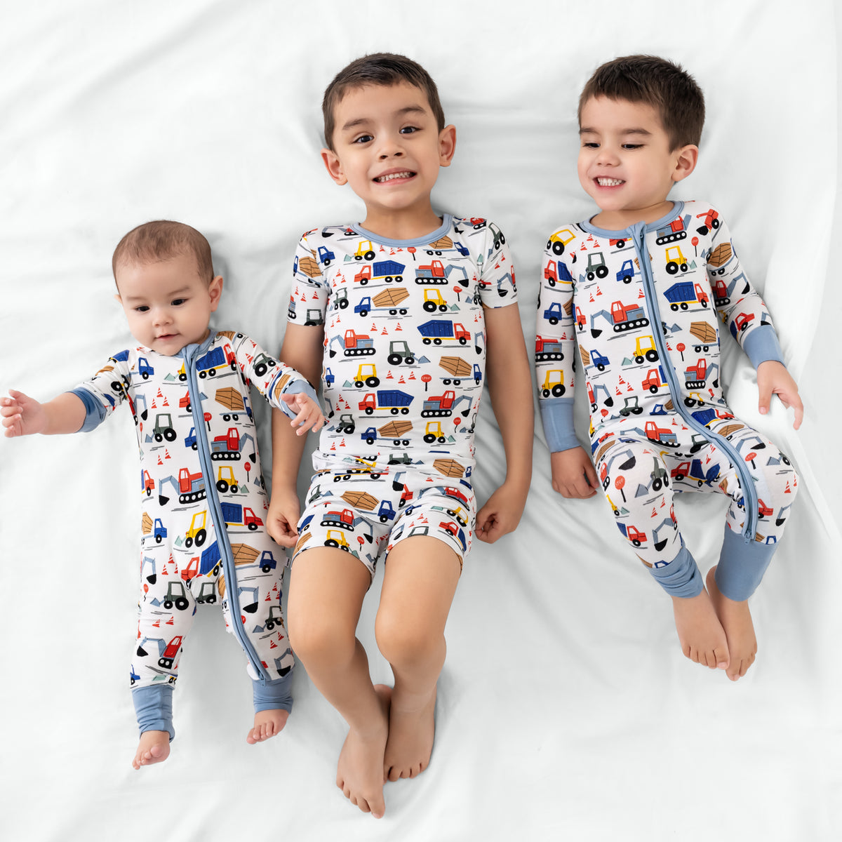 Three children wearing Construction print bamboo pajamas