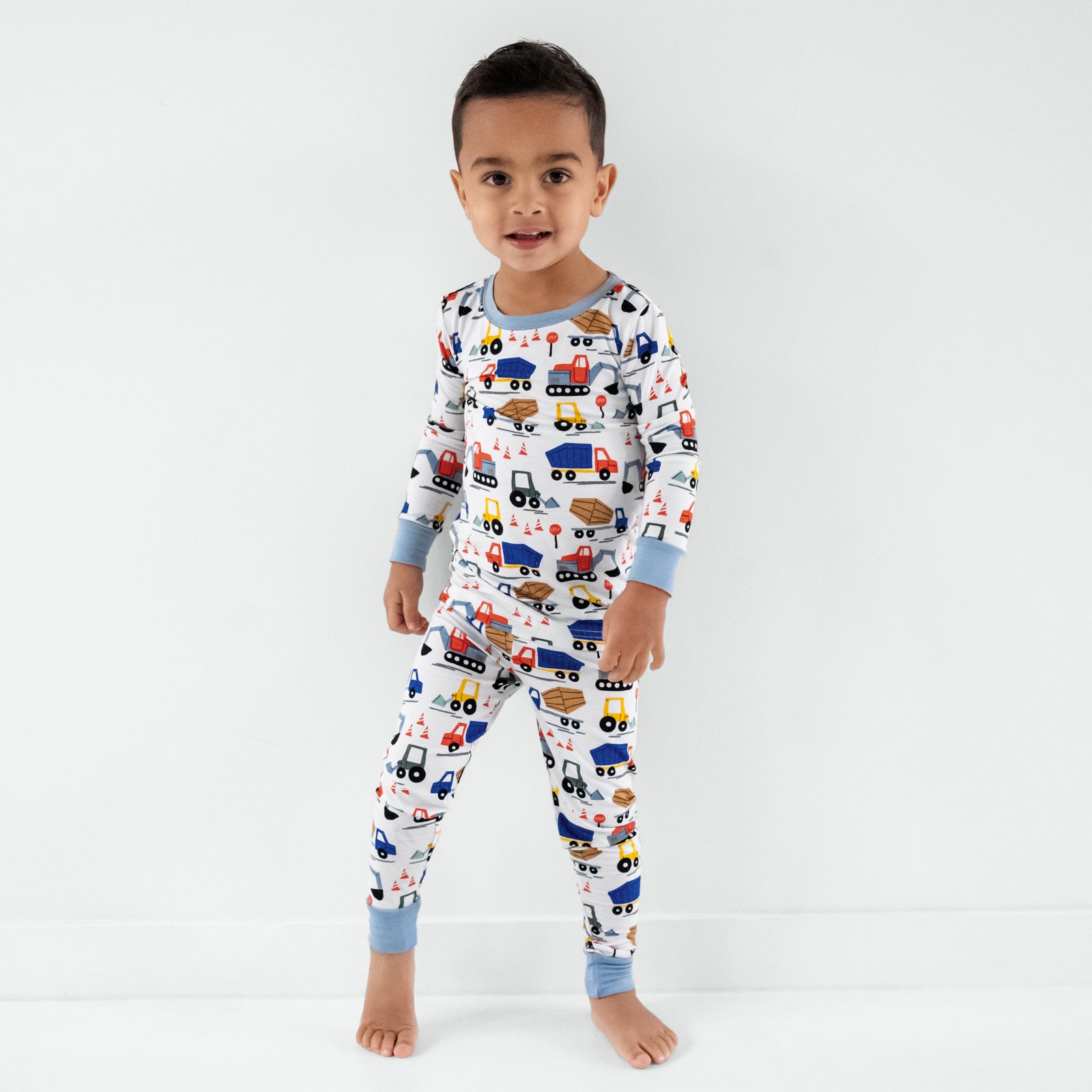 Standing child wearing the Construction Two-Piece Pajama Set