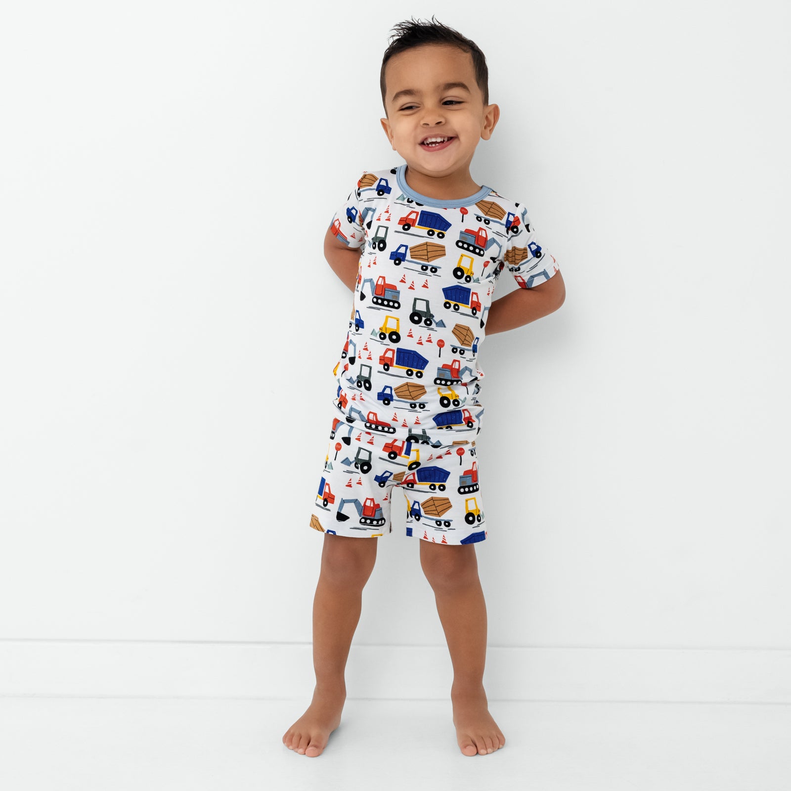 Standing child wearing the Construction Two-Piece Short Sleeve & Shorts Pajama Set
