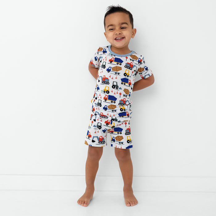Standing child wearing the Construction Two-Piece Short Sleeve & Shorts Pajama Set