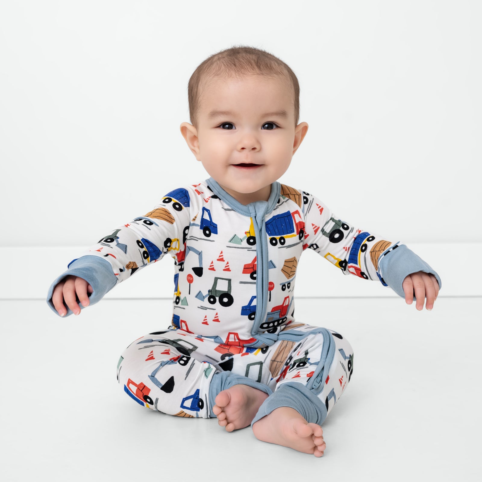 Sitting child wearing the Construction Zippy