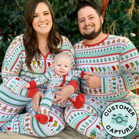 Customer Capture image of a family of three wearing matching Fair Isle pajamas. Woman is wearing Fair Isle women's pajama top and pants, Dad is wearing men's Fair Isle pajama top and pants. Child is wearing a Fair Isle zippy