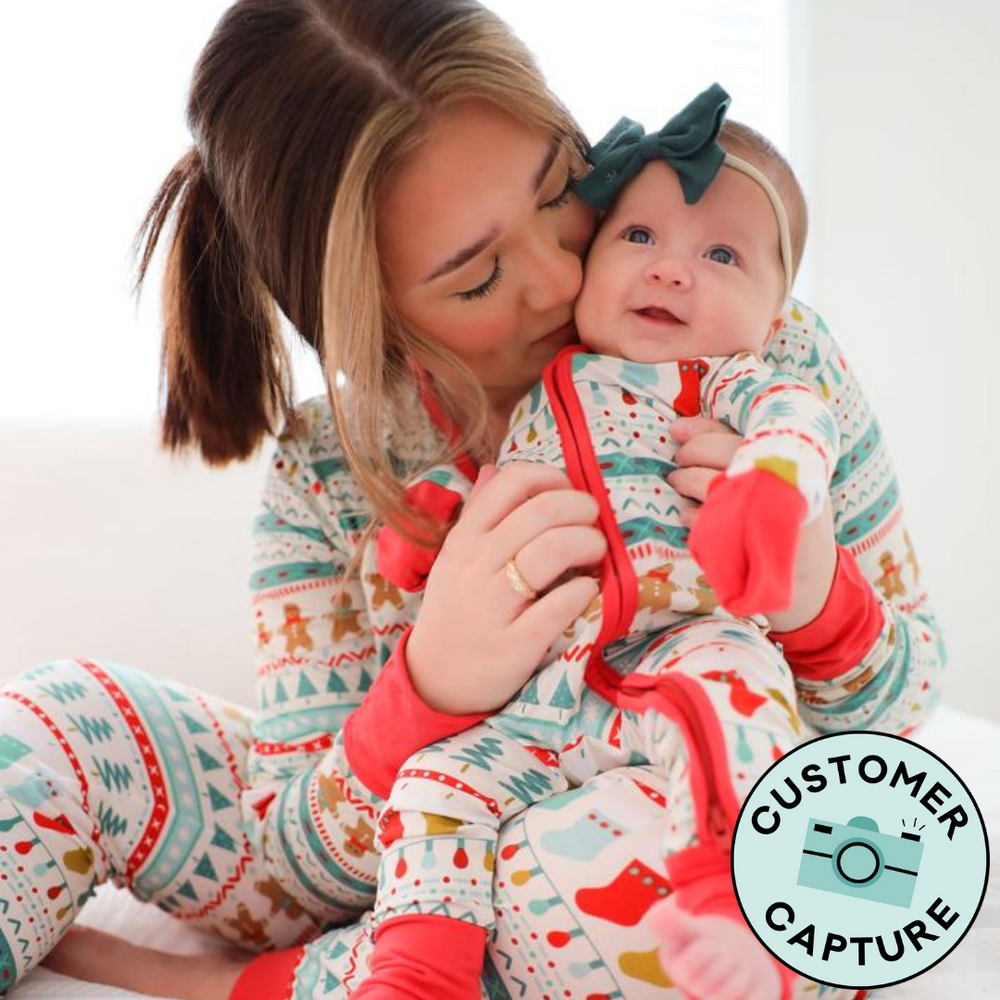 Customer Capture image of a mother and child cuddling together in matching in Fair Isle pajamas. Mom is wearing women's Fair Isle pajama top and matching women's pajama pants, her child is wearing a matching zippy