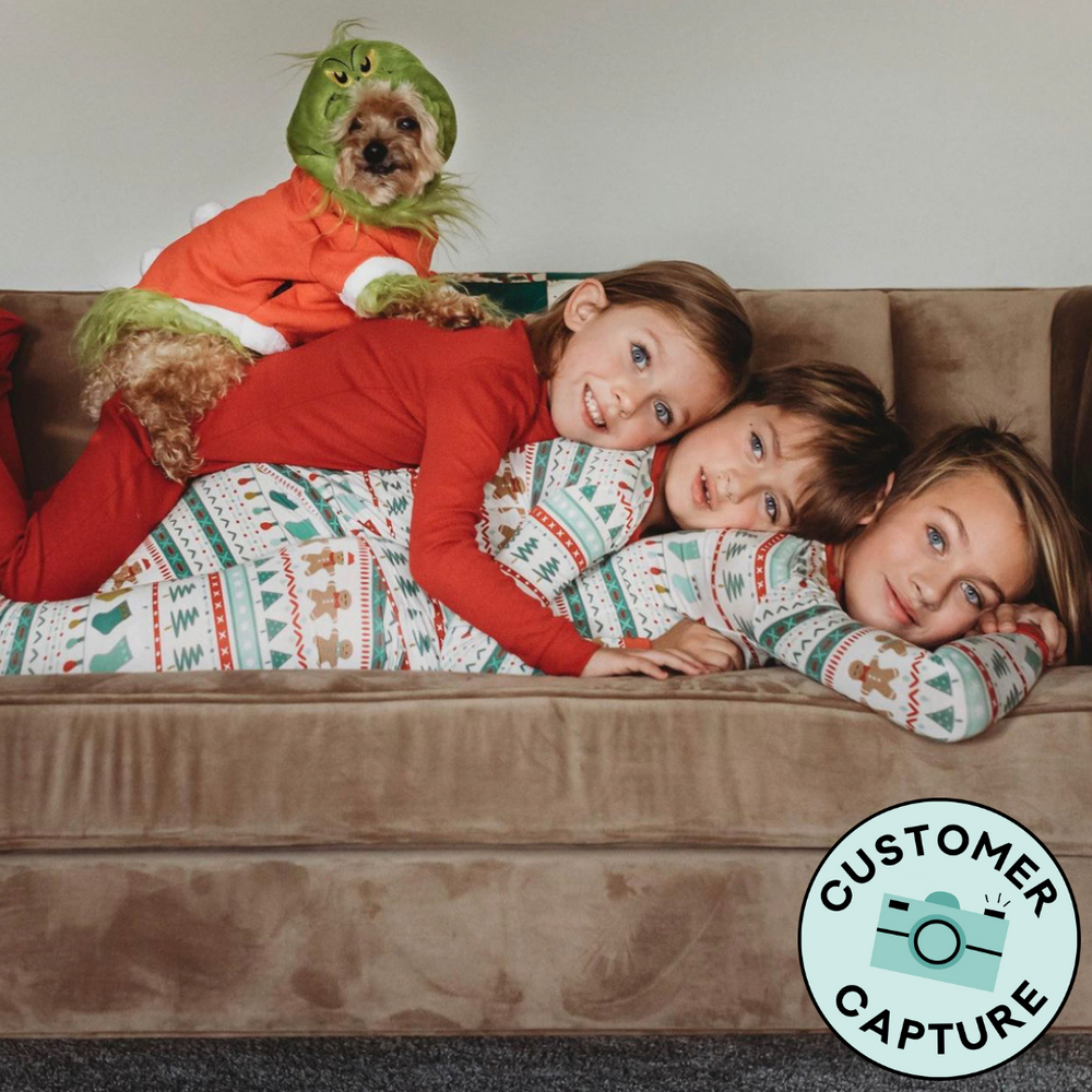 Customer Capture image of three children laying on top of each other wearing two piece Fair isle pajama sets. The third child is wearing a Holiday Red two piece pajama set