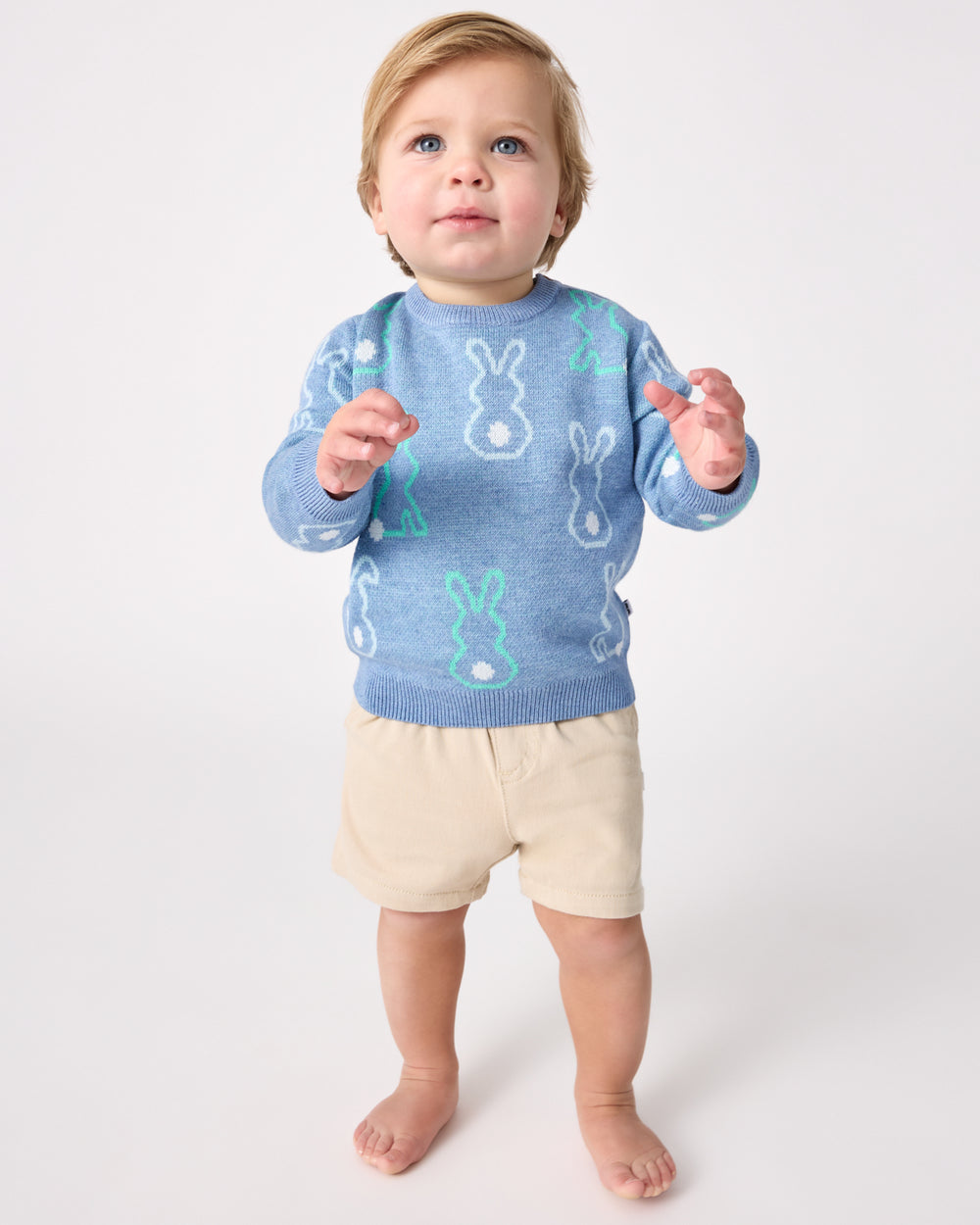 Toddler wearing the Cozy Cottontails Baby Sweater with khaki chino shorts