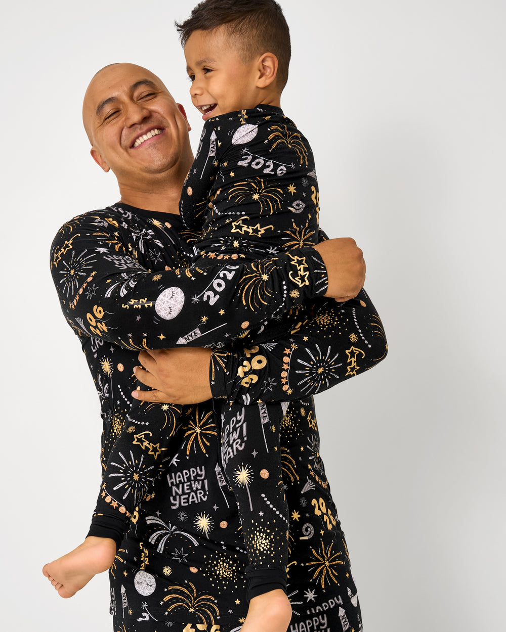 Father and son wearing matching Cozy Countdown New Years themed pajamas