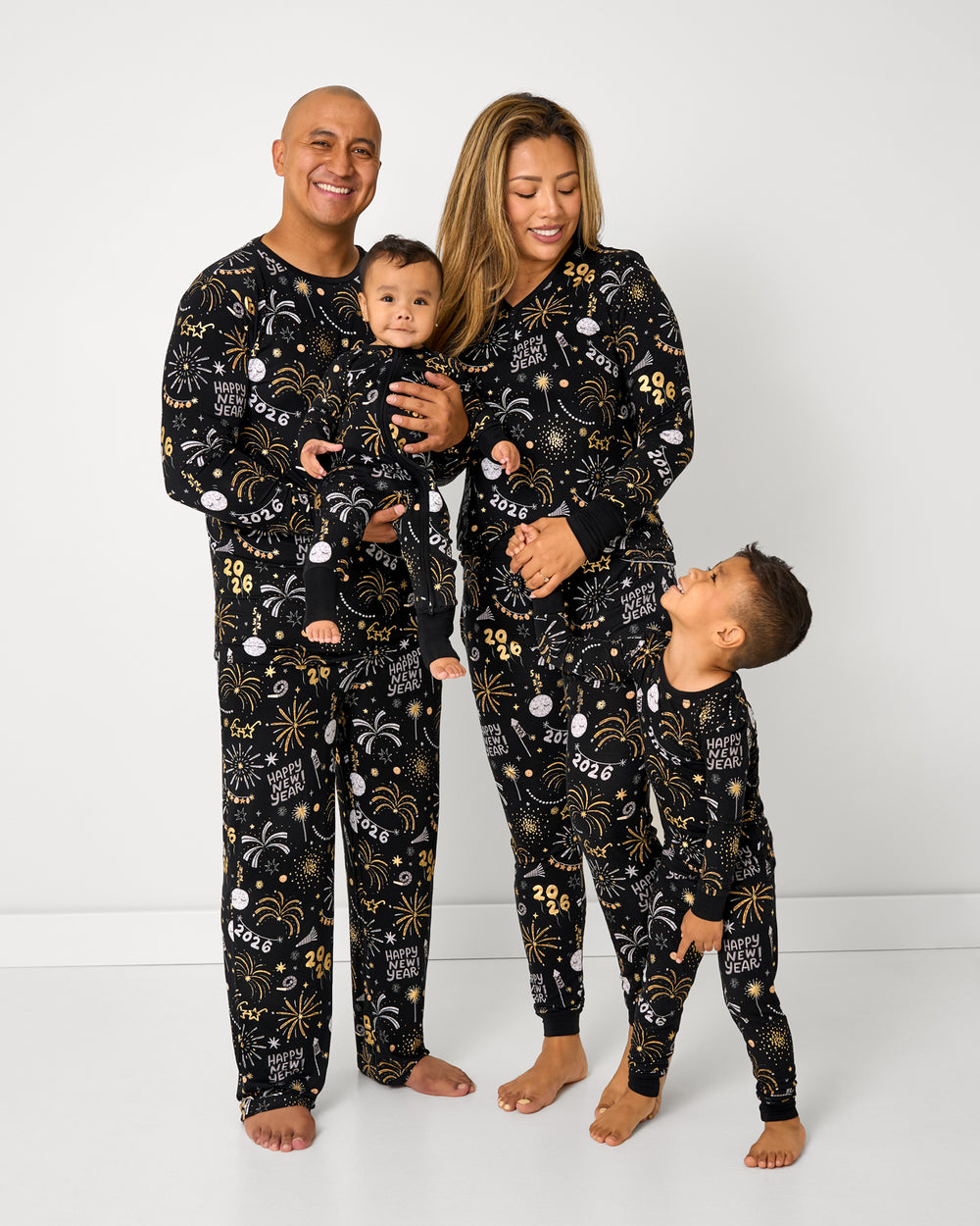 Standing family of four wearing matching Cozy Countdown NYE Pajamas