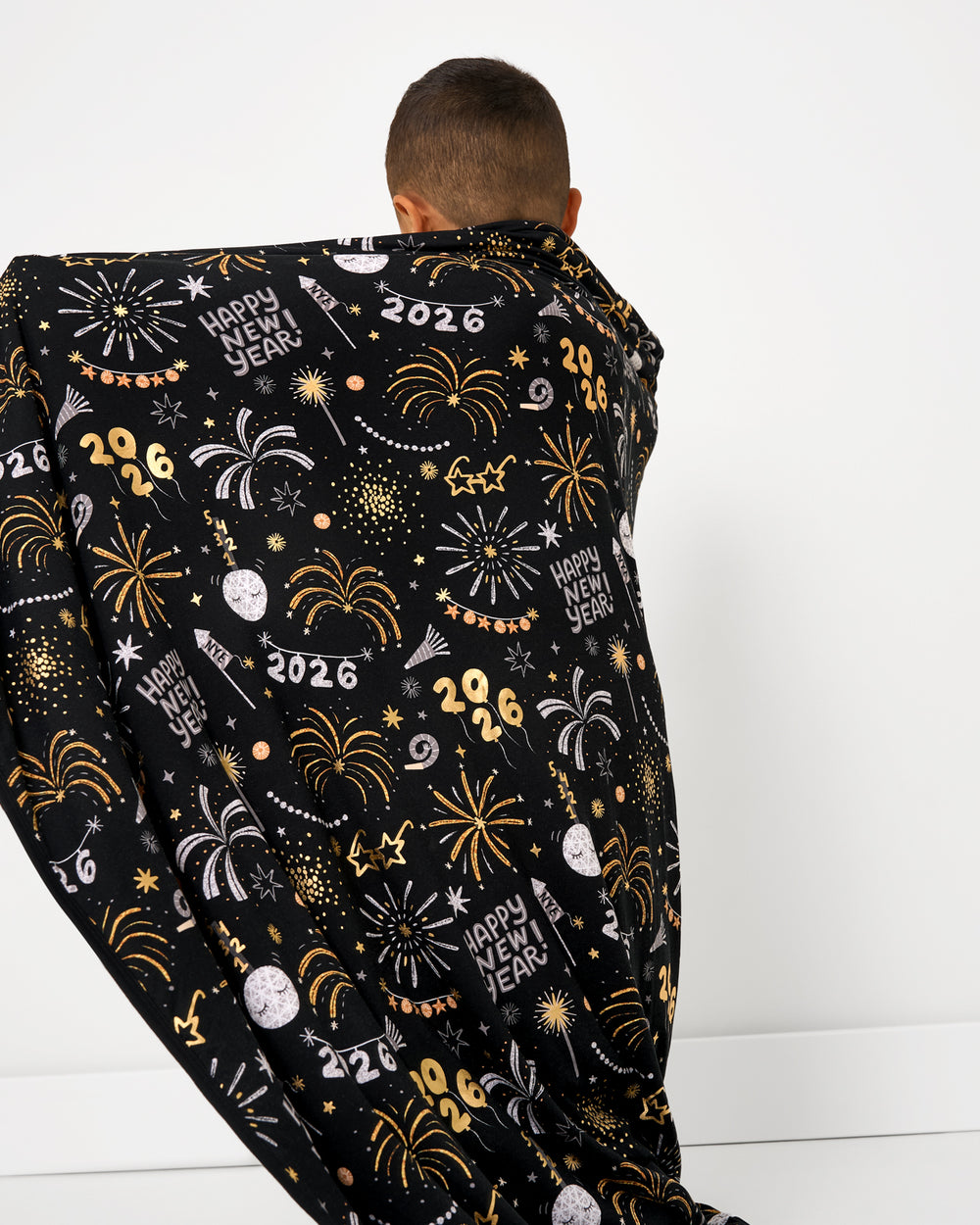 Back view of boy wrapped in the Cozy Countdown Large Cloud Blanket®