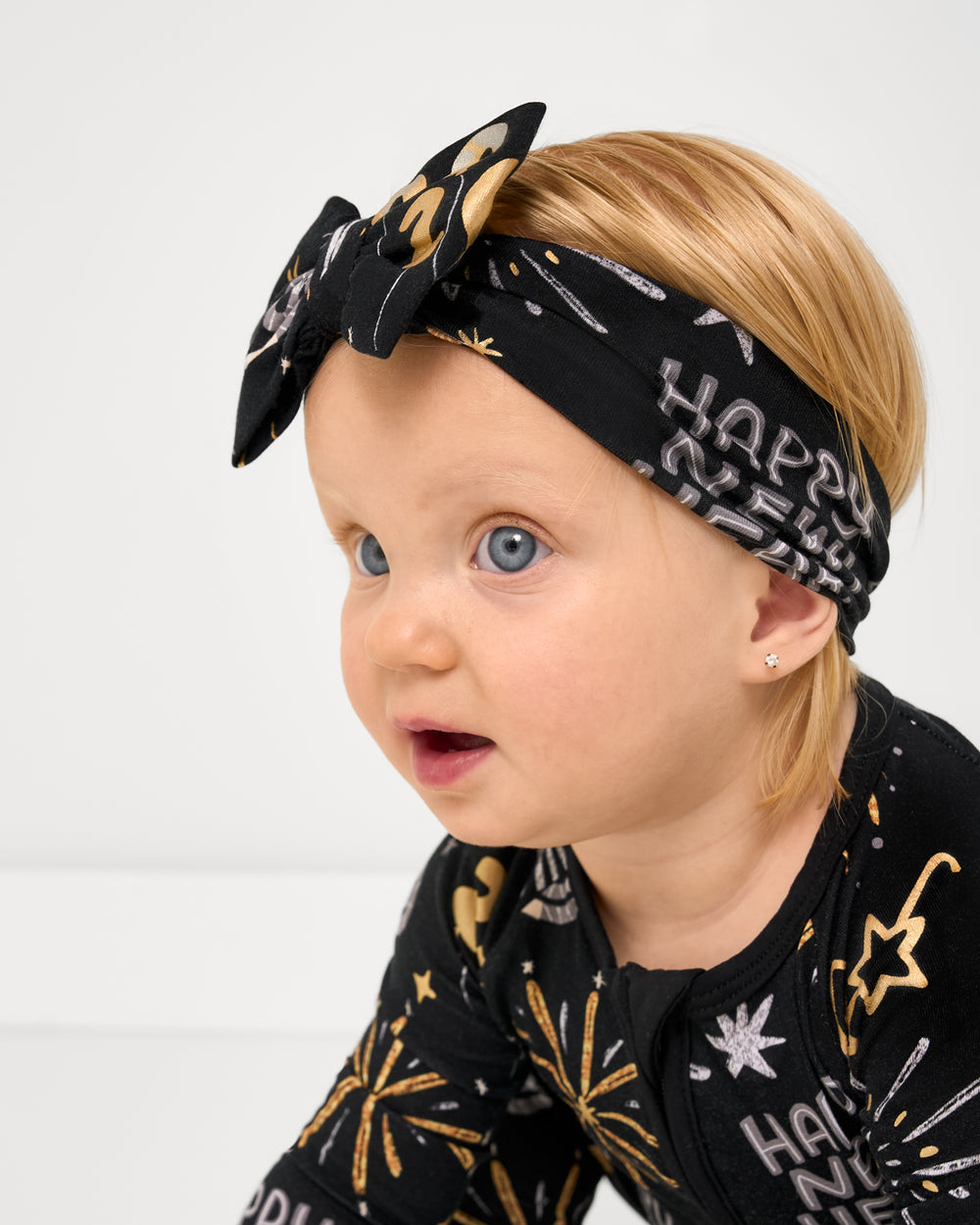 Close up of baby wearing the Cozy Countdown Luxe Bow Headband