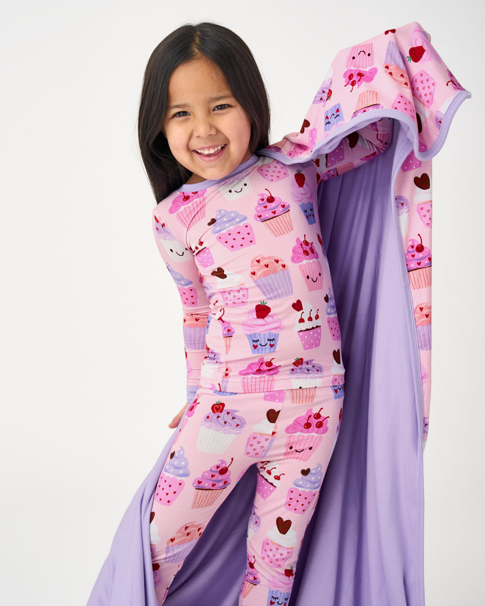Standing girl wrapped in the Cupcake Kisses Large Cloud Blanket® showing the solid purple side