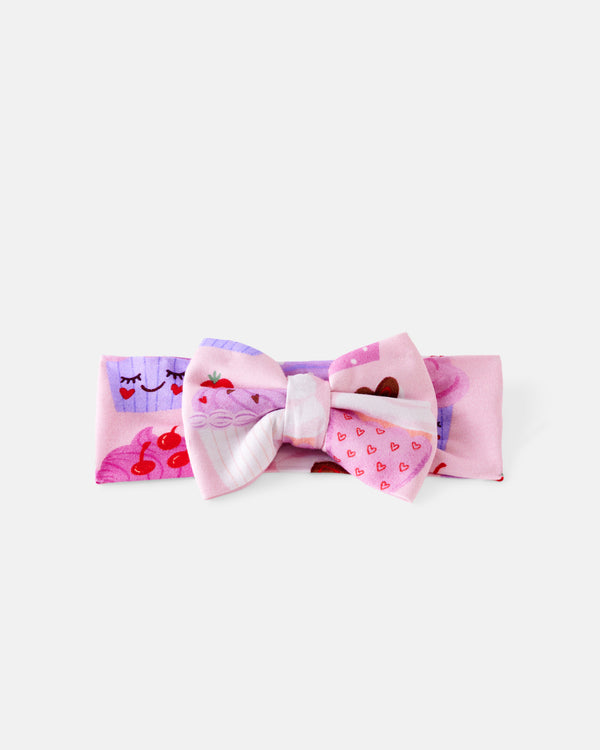 Flat lay of the Cupcake Kisses Luxe Bow Headband