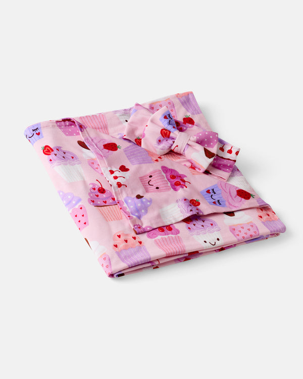Flat lay of the Cupcake Kisses Swaddle & Luxe Bow Headband Set