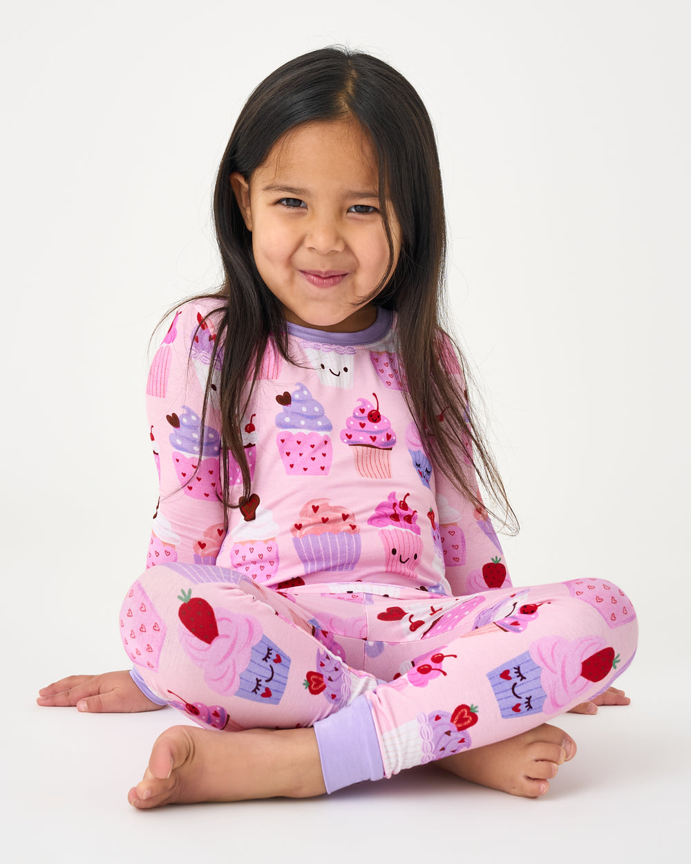 Sitting child wearing the Cupcake Kisses Two-Piece Pajama Set