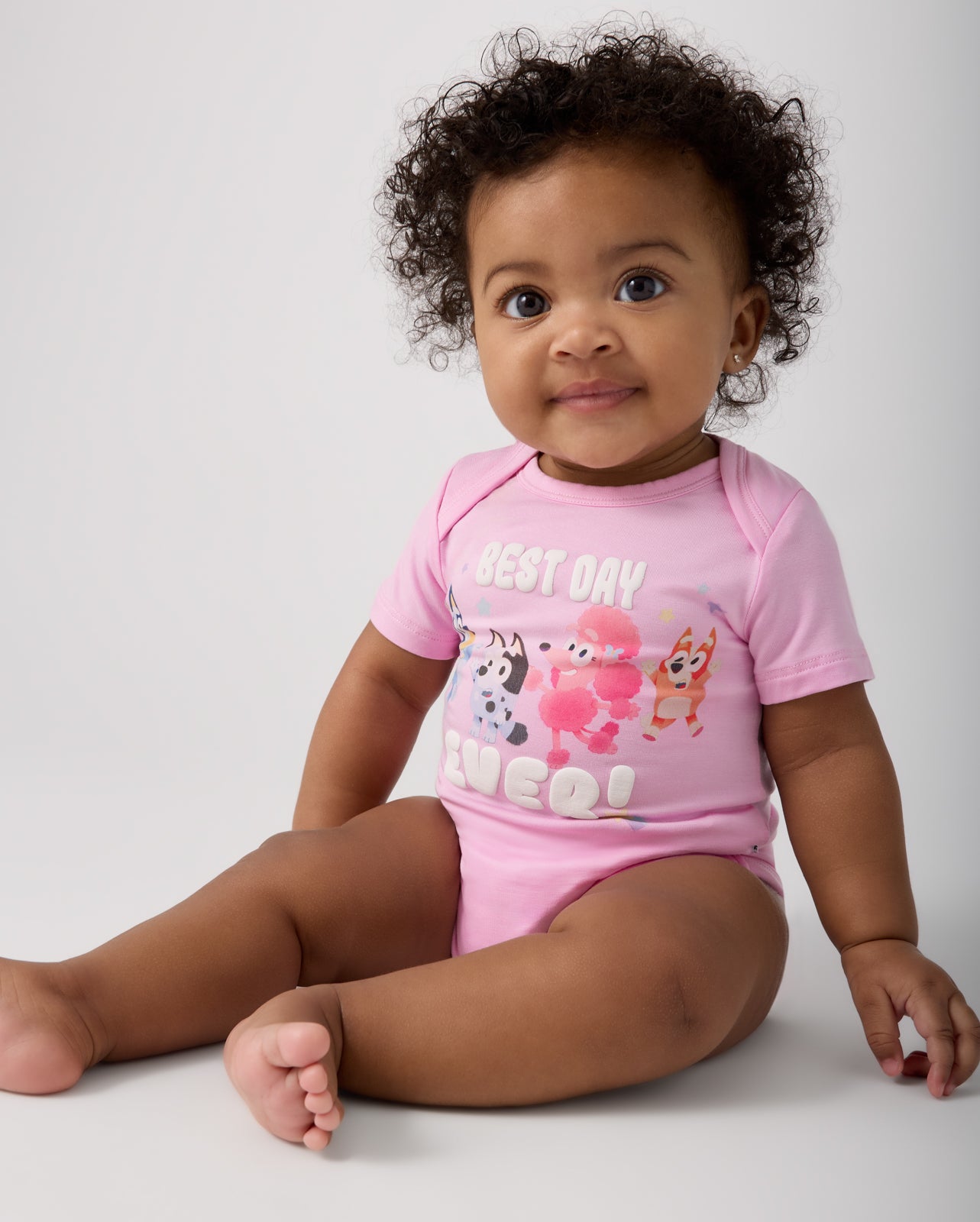 Sitting baby wearing the Bluey Best Day Ever Bodysuit