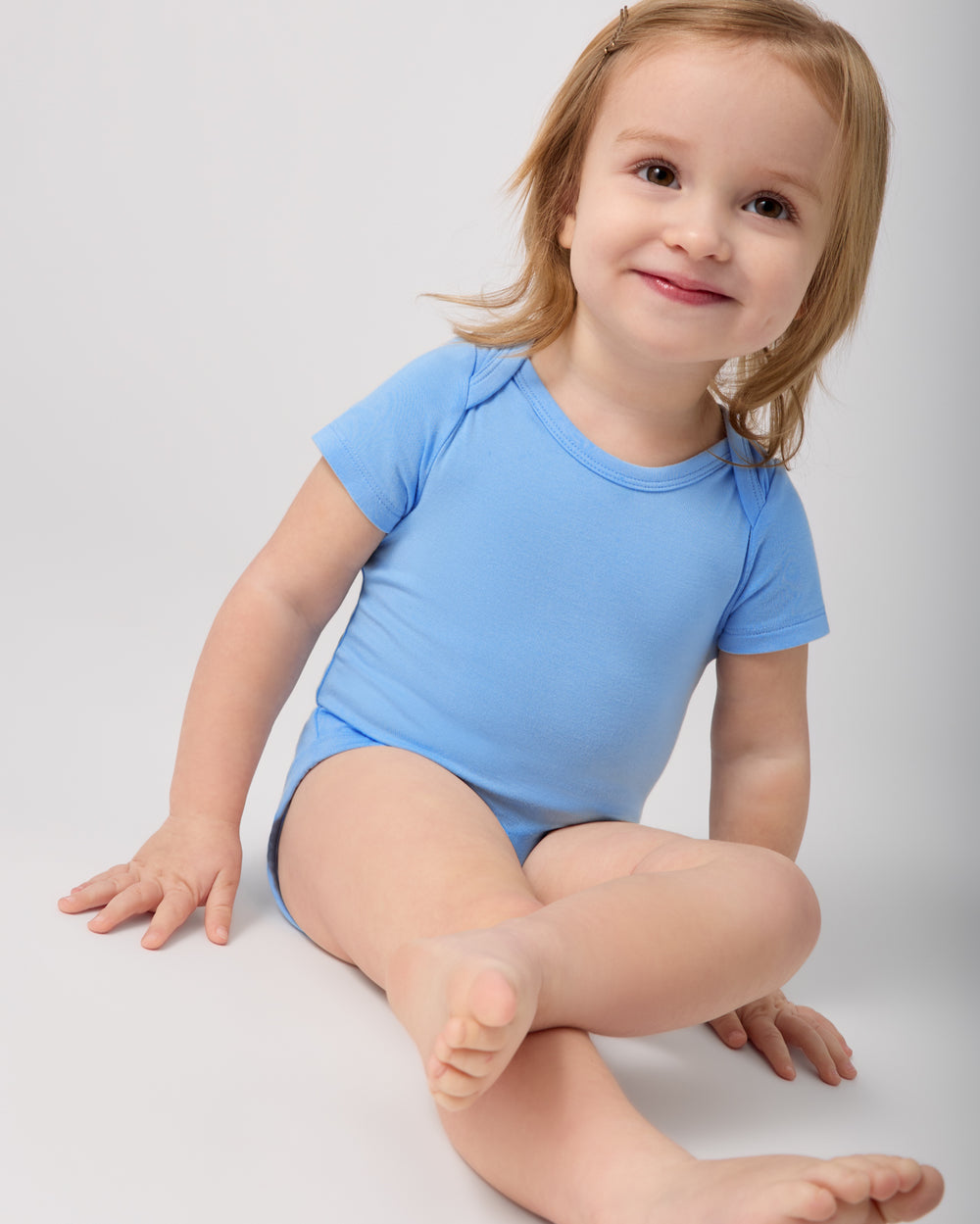 Sitting baby wearing the Blue Breeze Short Sleeve Bodysuit