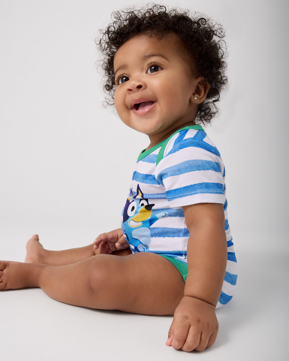 Side view of sitting baby wearing the Bluey Bodysuit