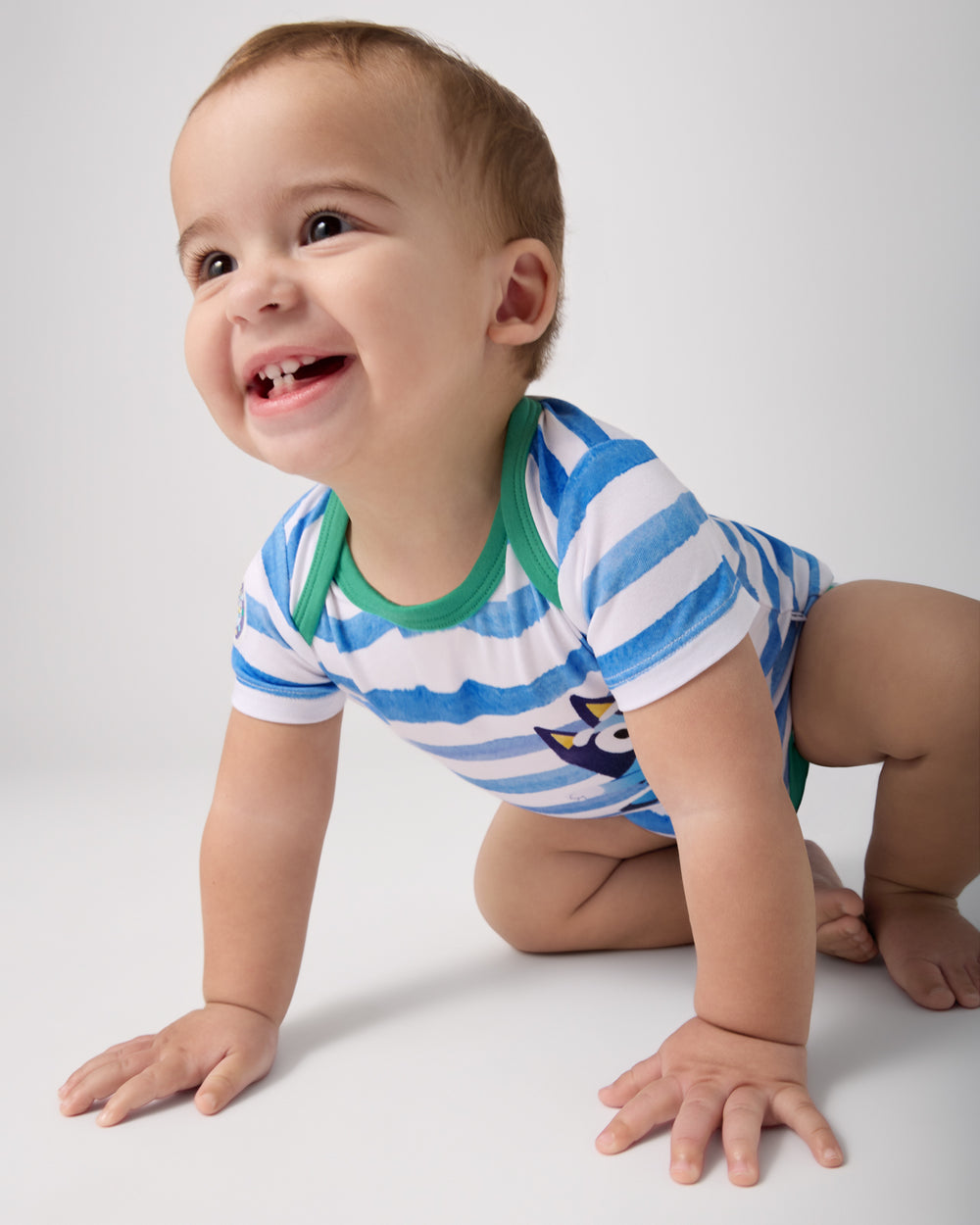 Crawling baby wearing the Bluey Bodysuit