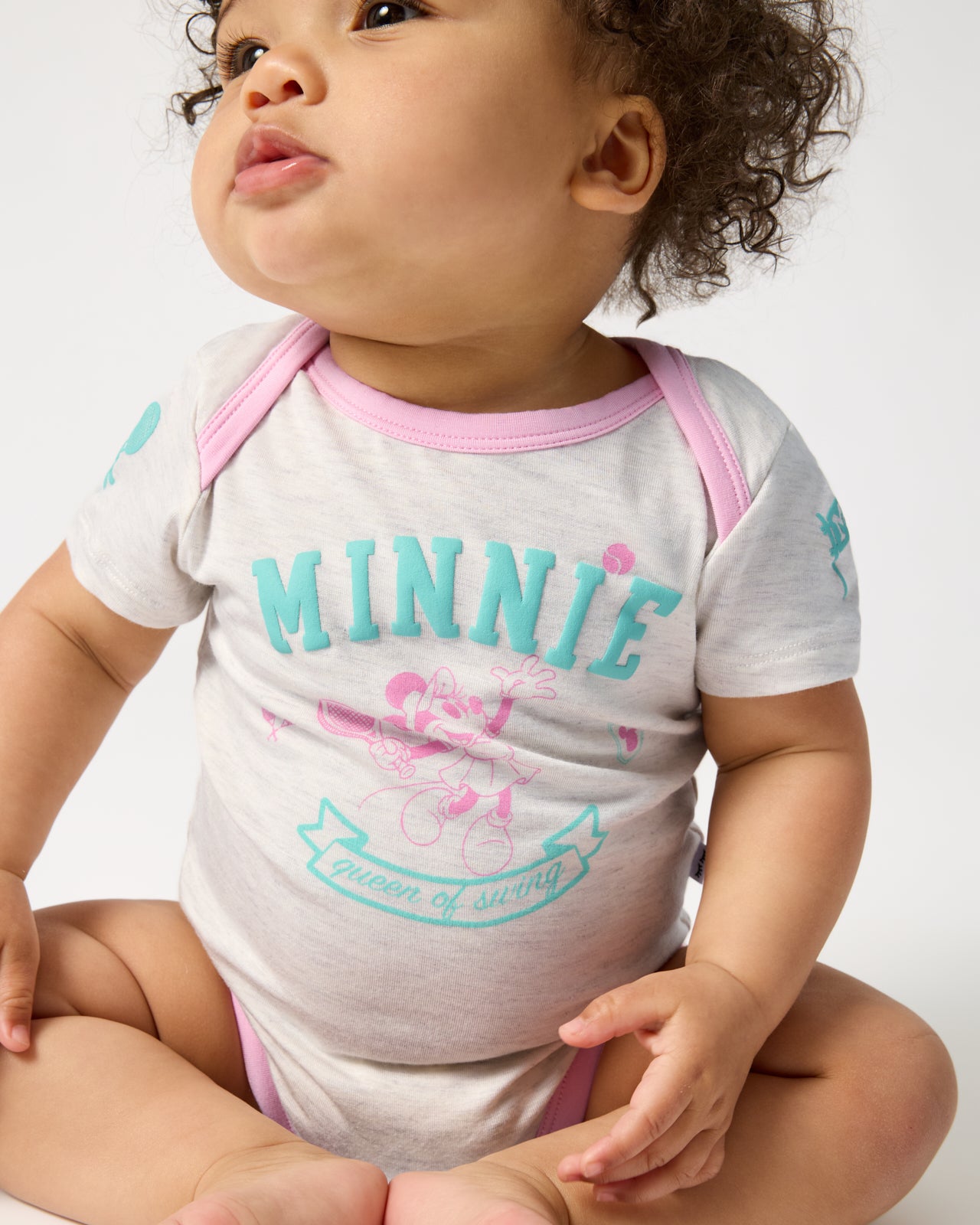 Sitting baby wearing the Disney Minnie Mouse Queen of Swing Bodysuit
