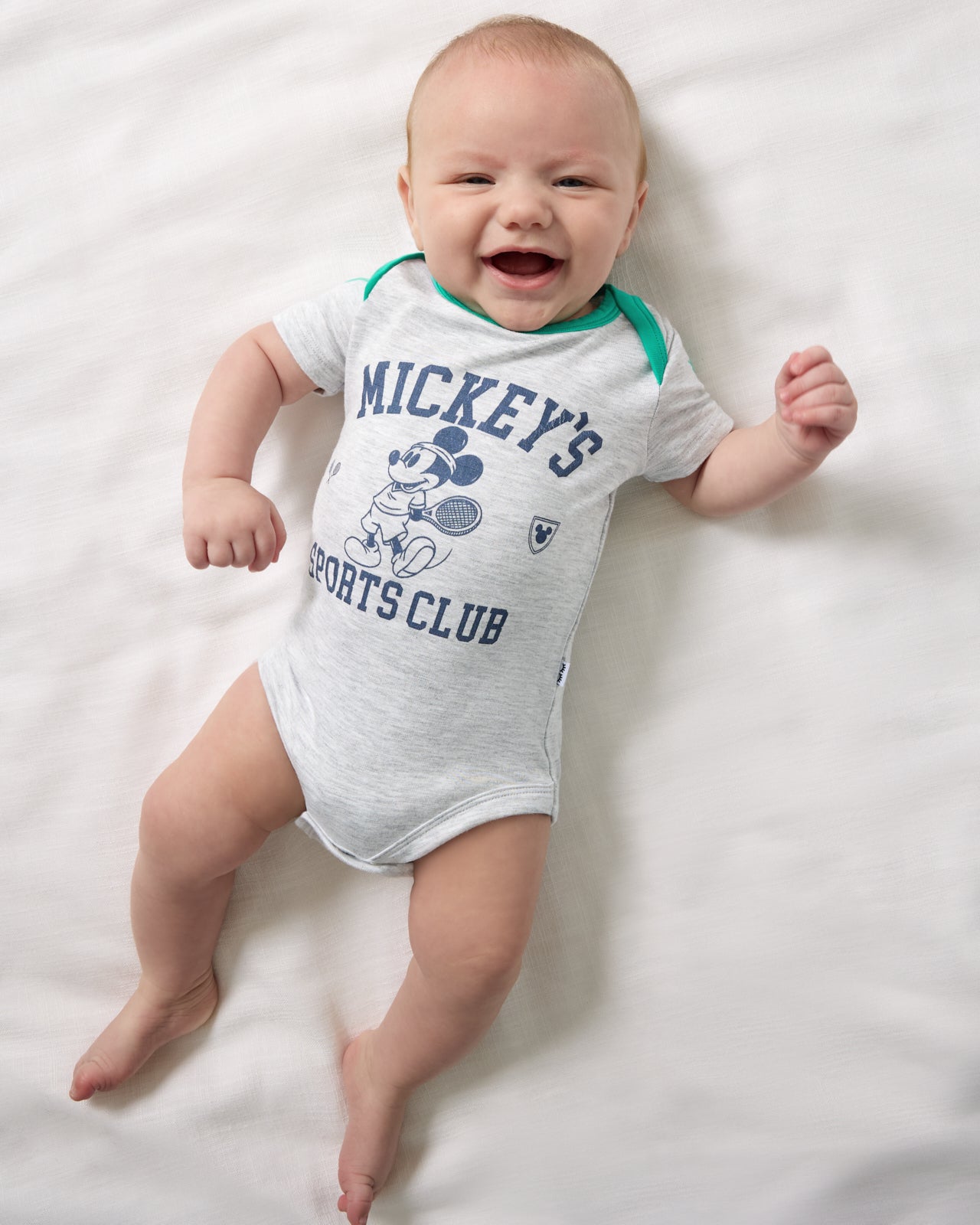 Aerial view of newborn wearing the Disney Mickey Mouse Sports Club Bodysuit