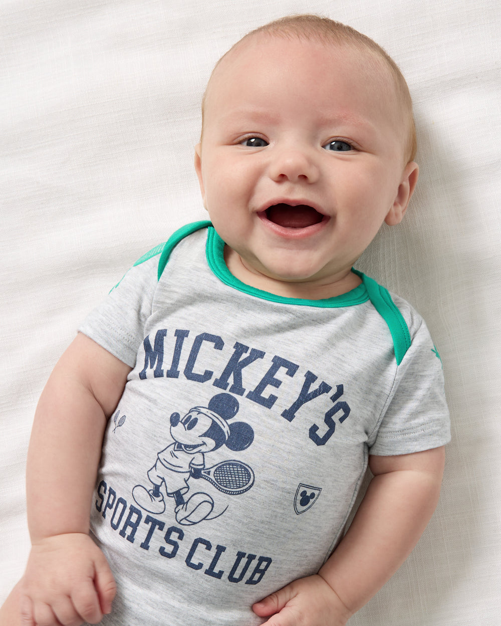 Close up overhead view of baby wearing the Disney Mickey Mouse Sports Club Bodysuit