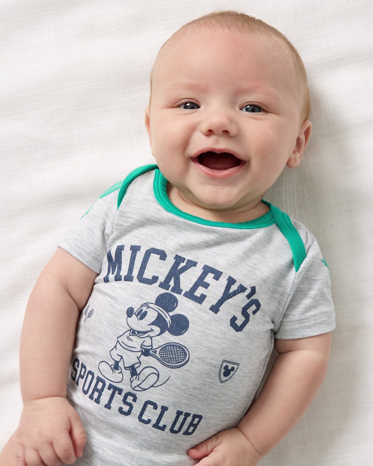Close up overhead view of baby wearing the Disney Mickey Mouse Sports Club Bodysuit
