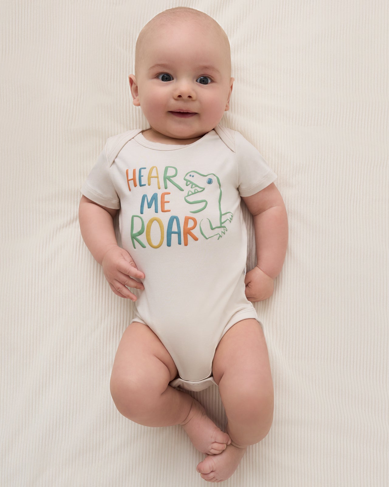 Aerial view of baby wearing the Hear Me Roar Bodysuit