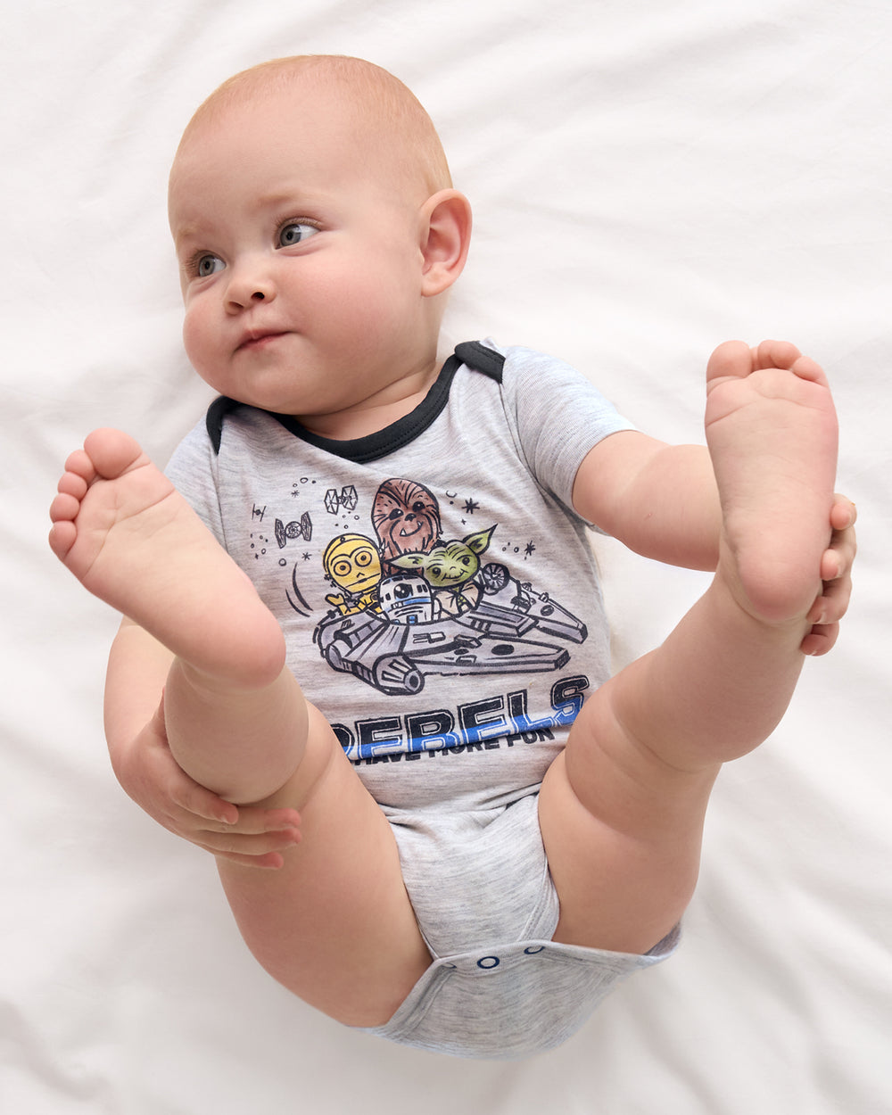 Overhead view of newborn wearing the Star Wars Little Rebels Short Sleeve Bodysuit