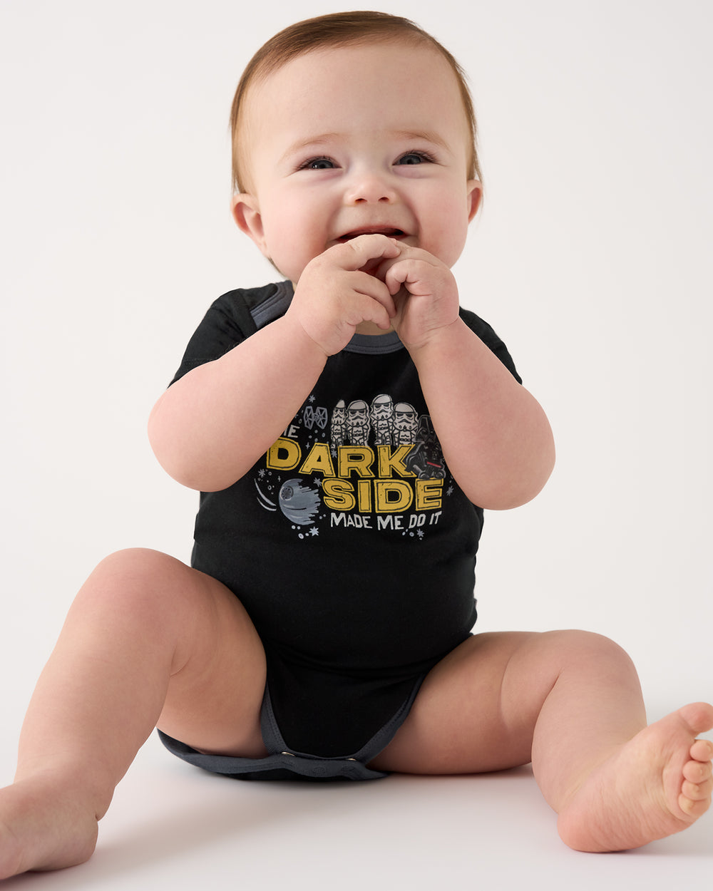 Sitting baby wearing the Star Wars Dark Side Short Sleeve Bodysuit