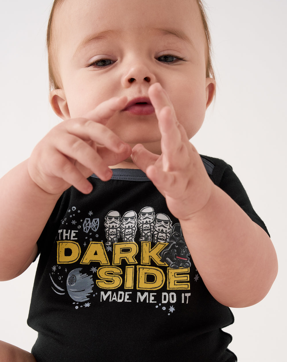 Close up of sitting baby wearing the Star Wars Dark Side Short Sleeve Bodysuit