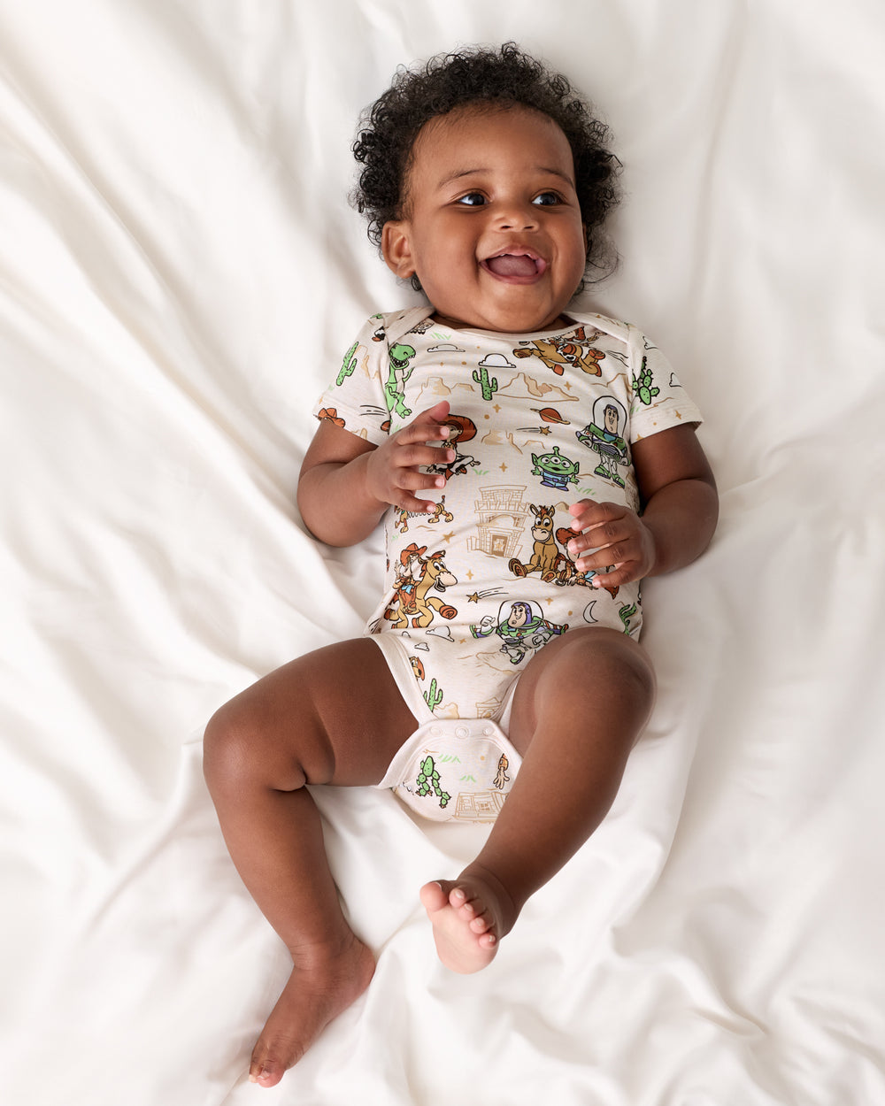 Aerial view of baby wearing the Disney & Pixar Woody's Wild West Bodysuit