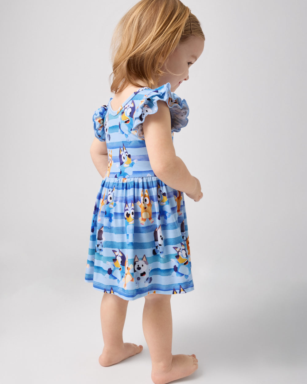 Back view of standing toddler wearing the Bluey Dance All Day Flutter Skater Dress with Bodysuit