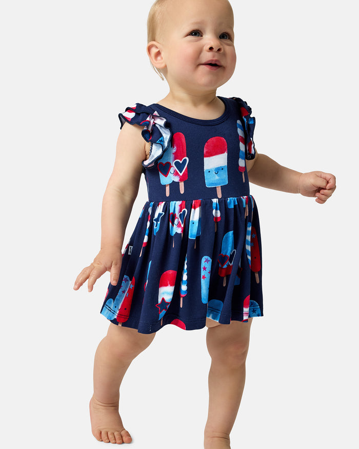Walking toddler wearing the Sparkle Treats Flutter Skater Dress with Bodysuit