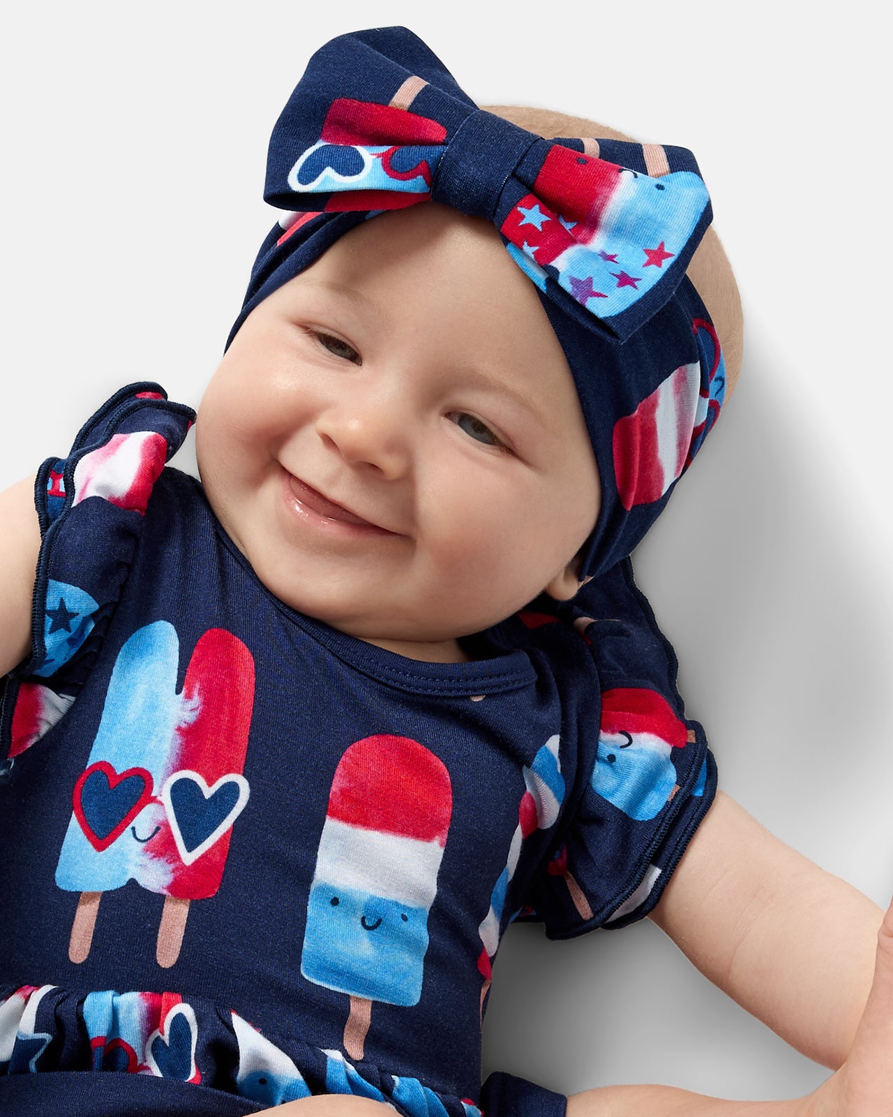 Close up of baby wearing the Sparkle Treats Luxe Bow Headband with a matching Flutter Dress