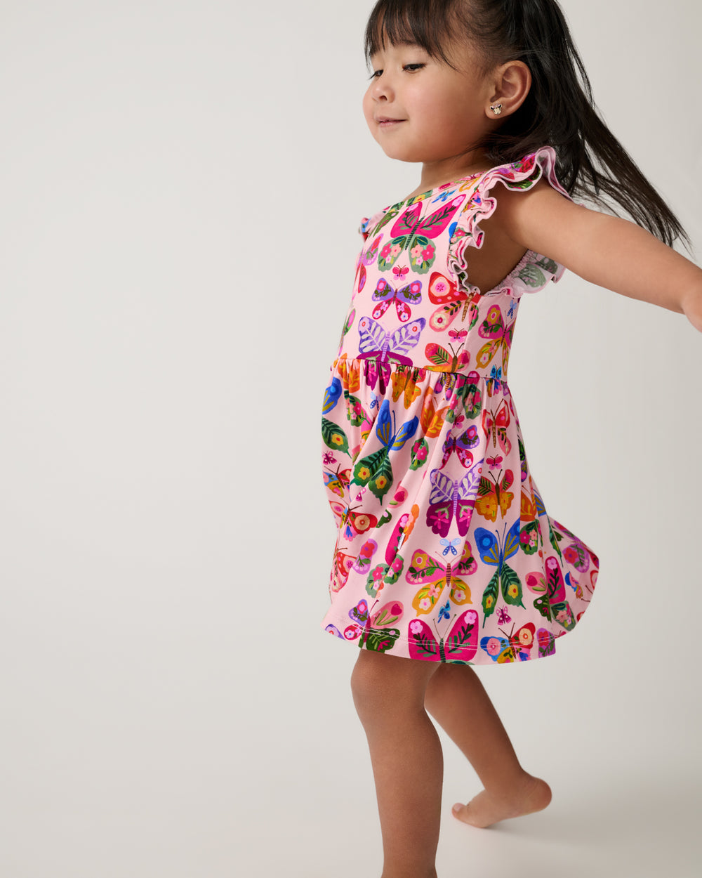 Walking girl wearing the Flutter Garden Skater Dress with Bodysuit