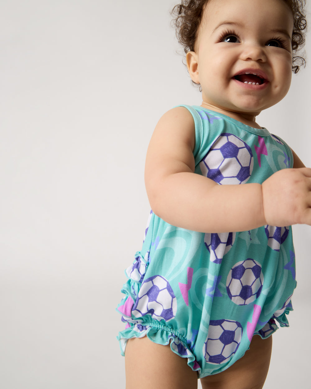 Close up of standing baby wearing the Aqua Soccer Stars Bubble Romper