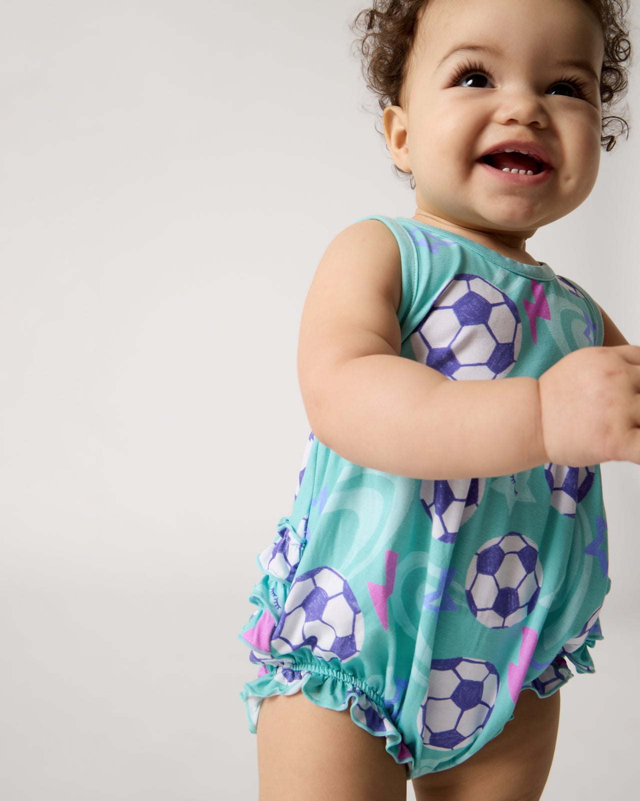 Close up of standing baby wearing the Aqua Soccer Stars Bubble Romper