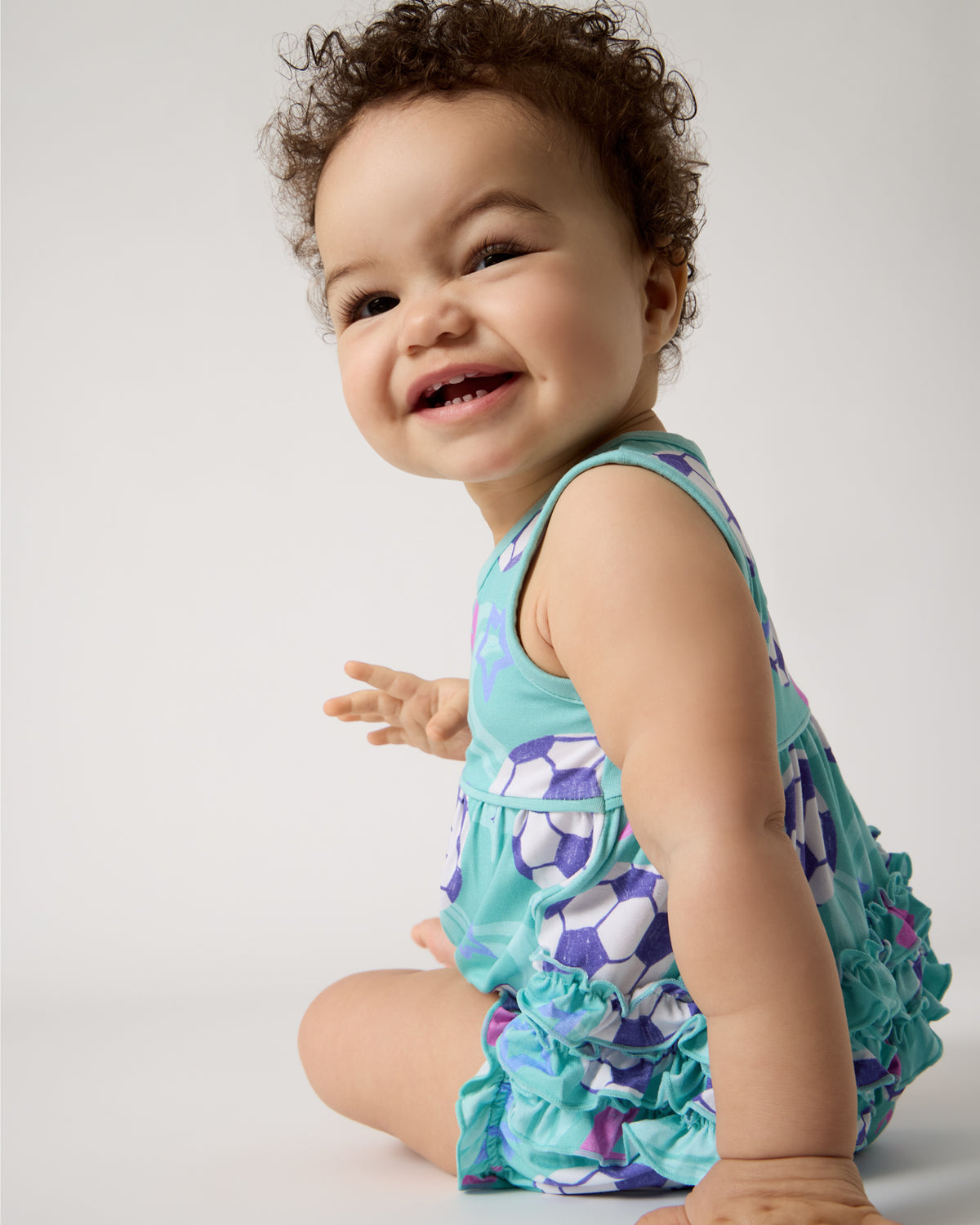 Back view of sitting baby wearing the Aqua Soccer Stars Bubble Romper