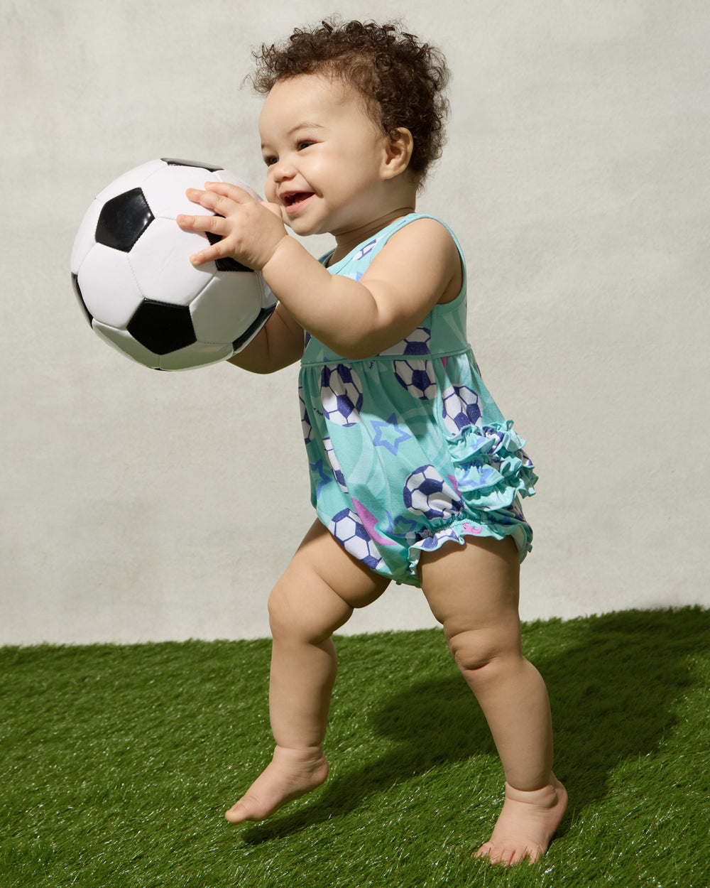 Baby wearing the Aqua Soccer Stars Bubble Romper playing with a soccer ball