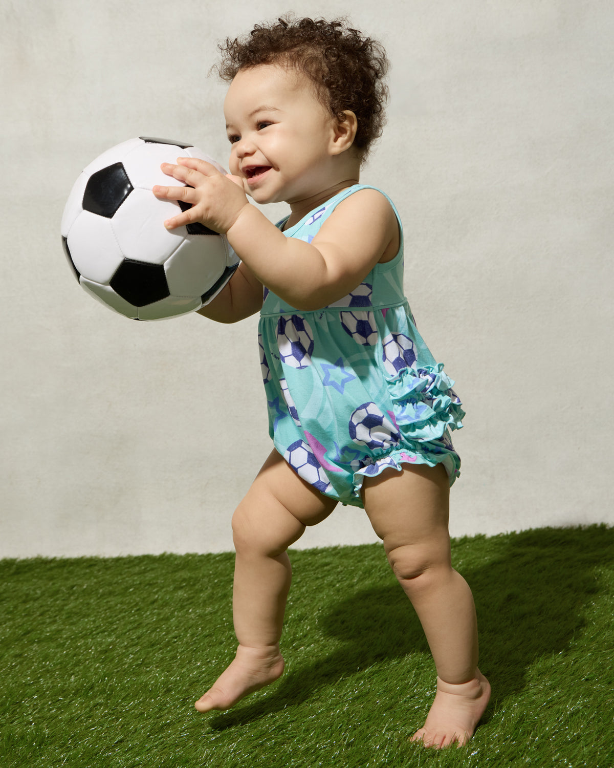 Baby wearing the Aqua Soccer Stars Bubble Romper playing with a soccer ball